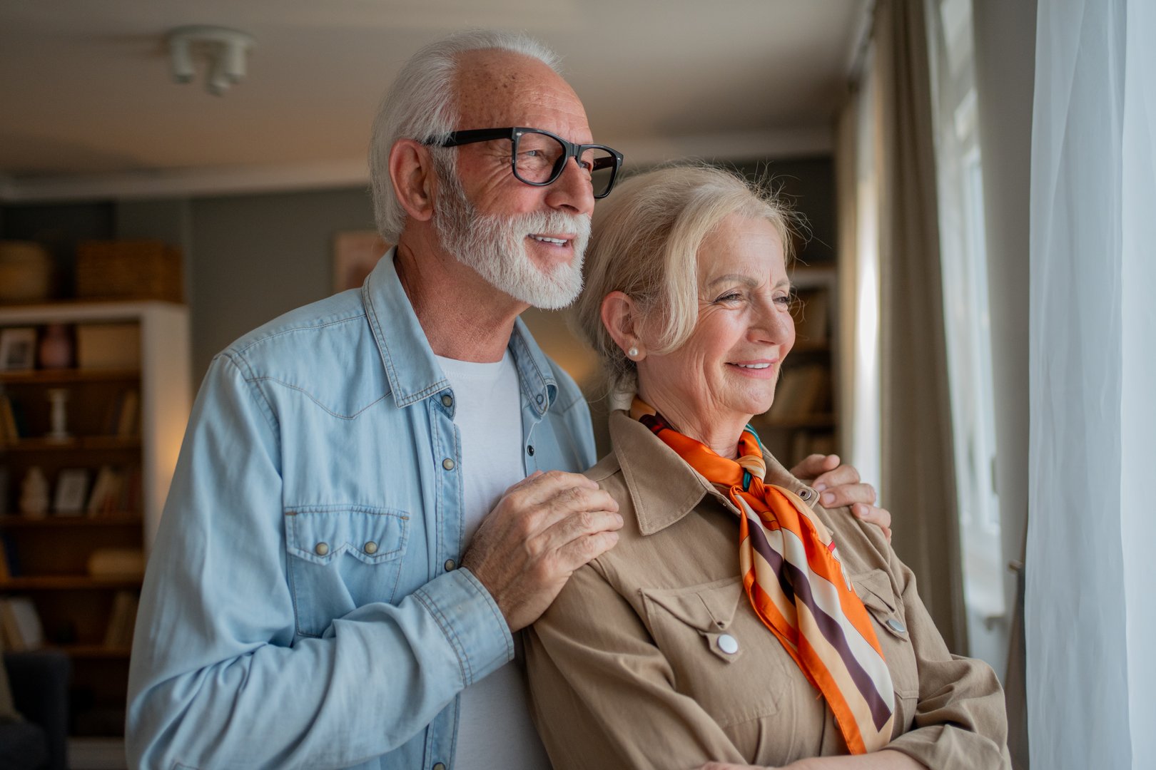 Senior couple looking through window thinking about retirement