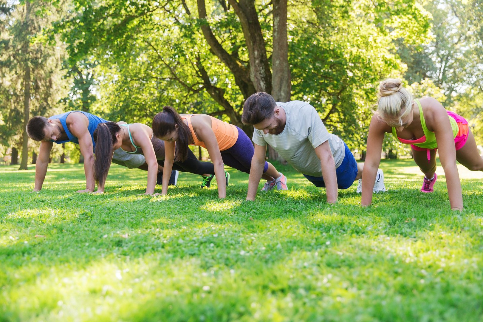 fitness, sport, friendship and healthy lifestyle concept - group of teenage friends or sportsmen exercising and doing push-ups at boot camp