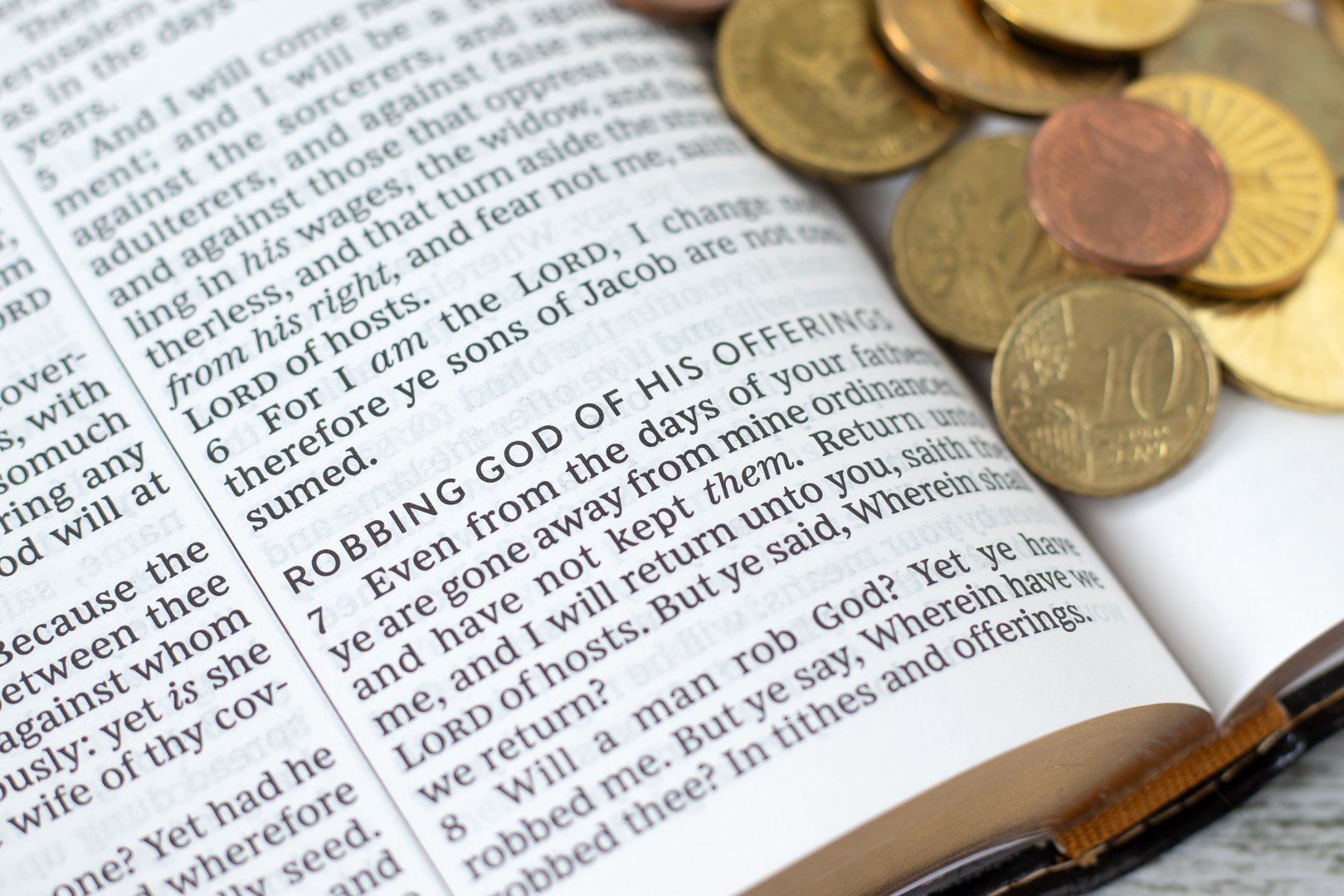 Holy bible book with coin money. Christian tithing and blessing from God Jesus Christ. Biblical concept. Close-up. Selective focus.