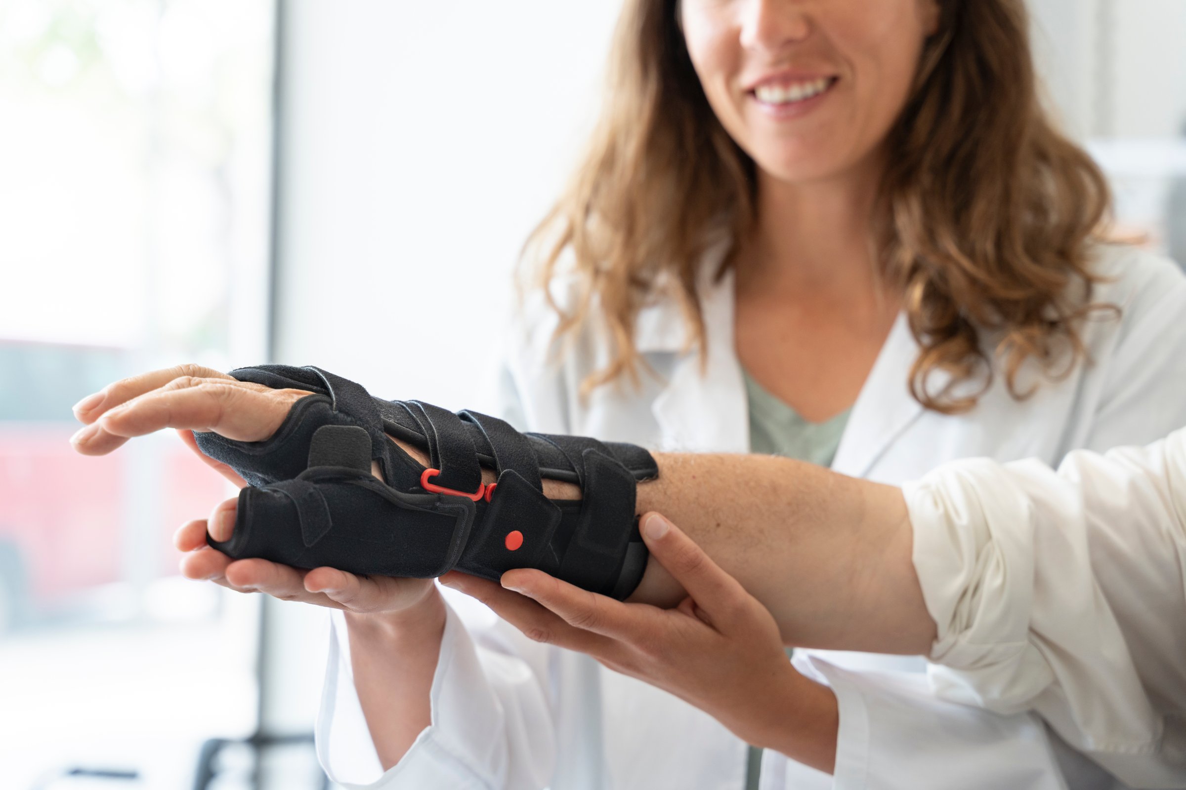 Senior man with gray hair trying on an orthopedic wrist brace