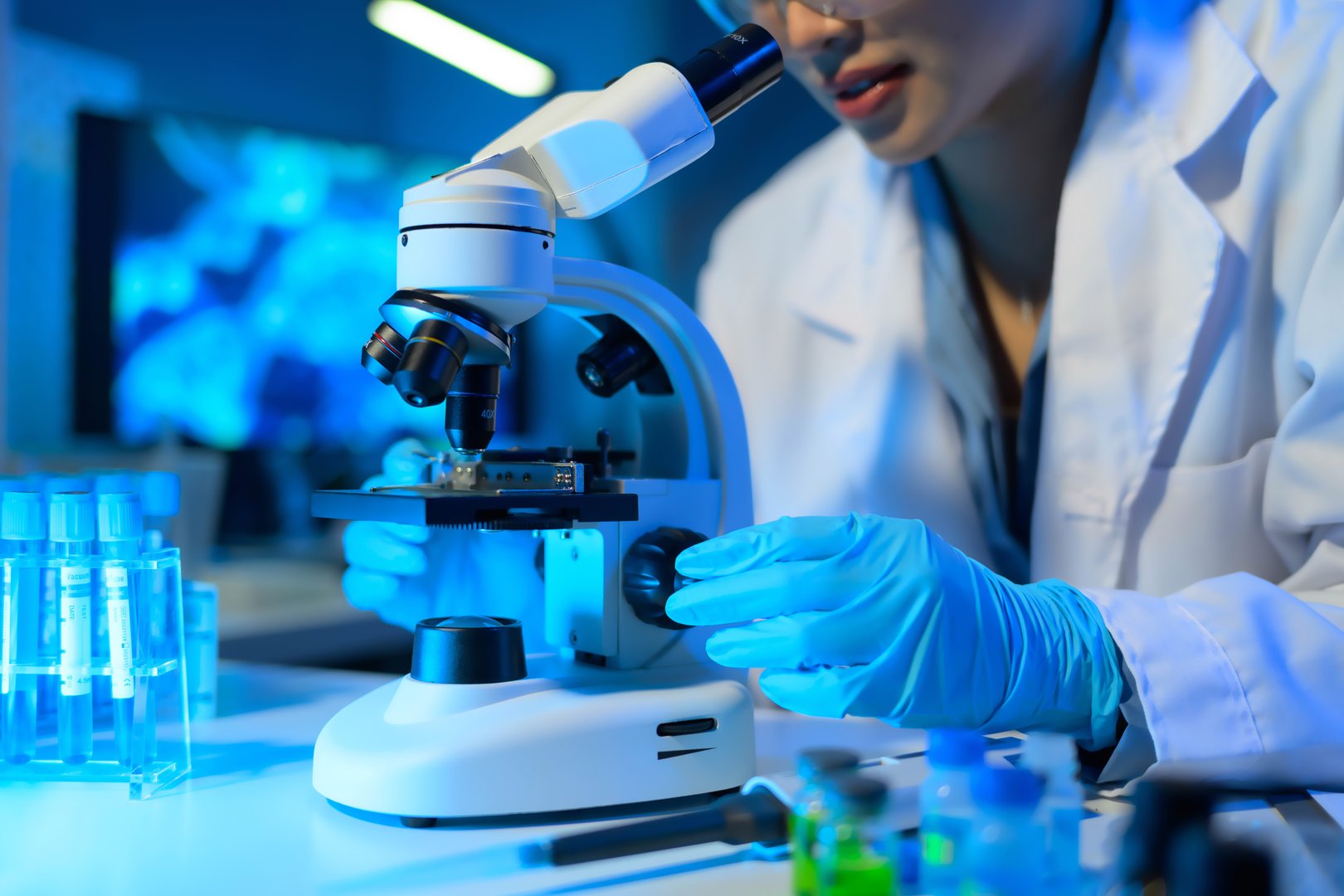 Female scientist using microscope in laboratory research