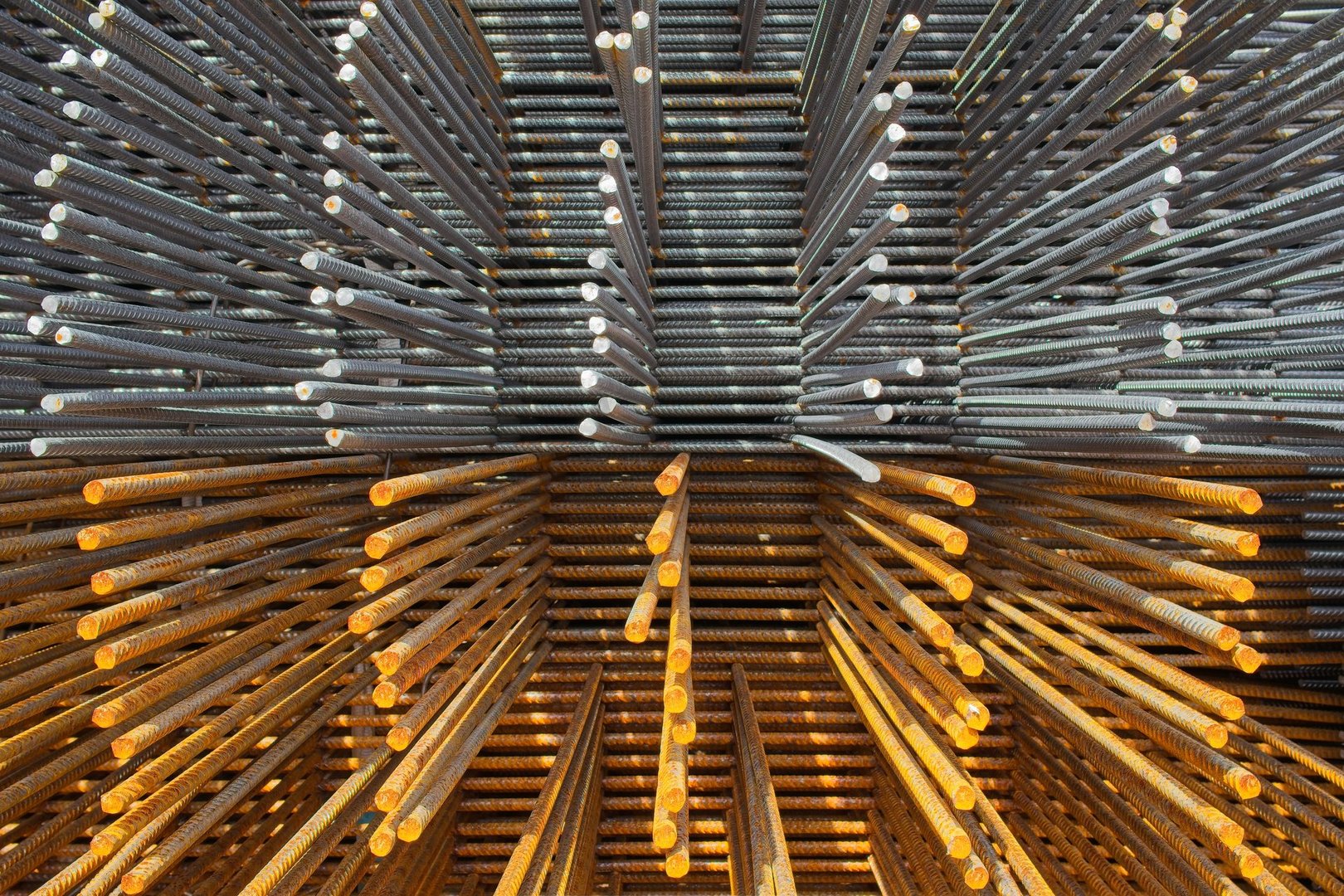 Ribbed steel bars for reinforced concrete in a construction site, showing oxidation and gray metal