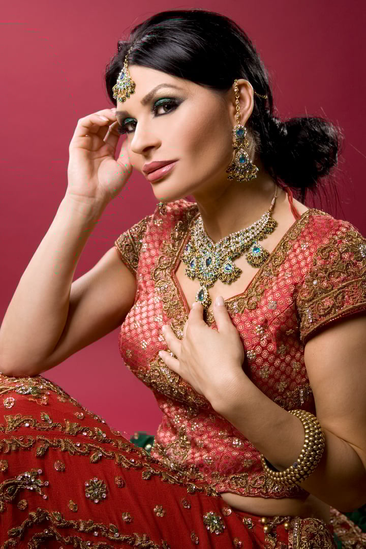 beautiful indian woman wearing bridal outfit on red