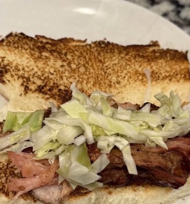 Topping the pork belly sliders with pickled cabbage