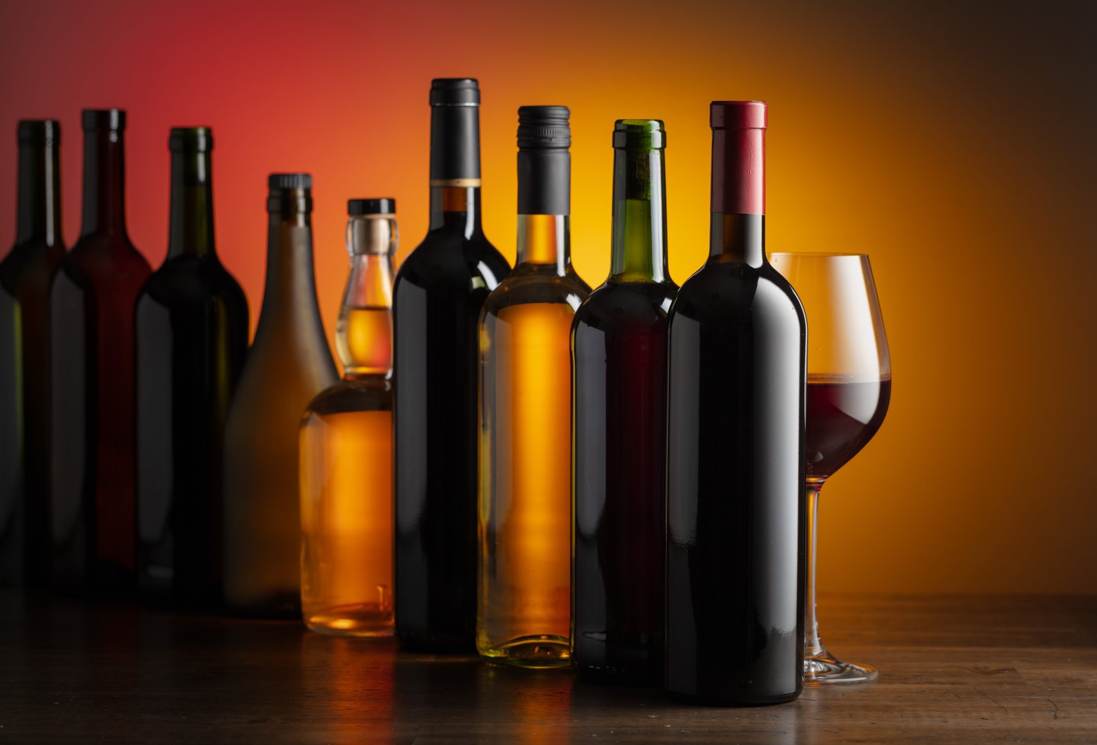 Bottles of wine on a old wooden table. Focus on foreground.
