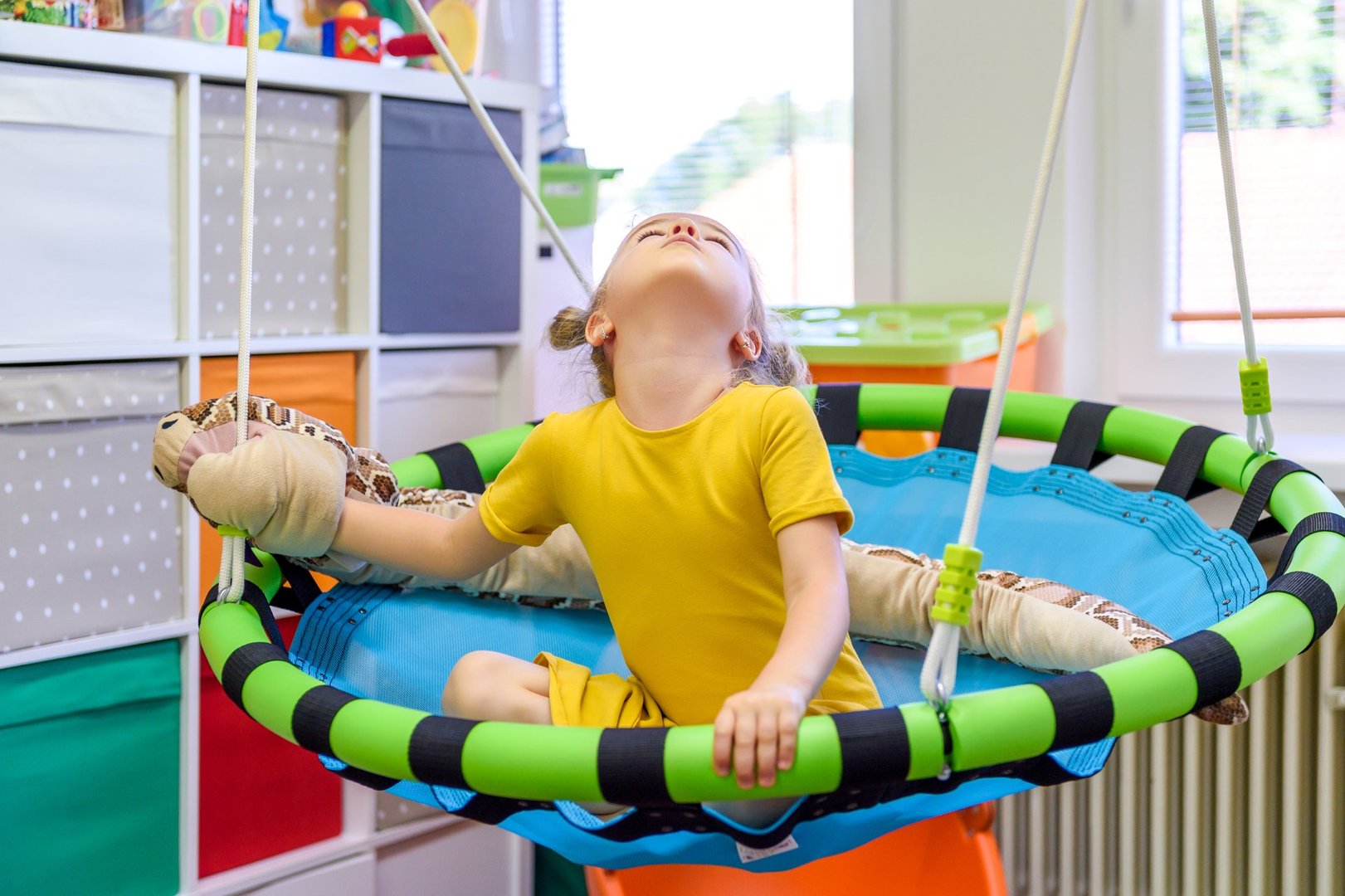 Cute preschool age girl playing with toys during occupational therapy.