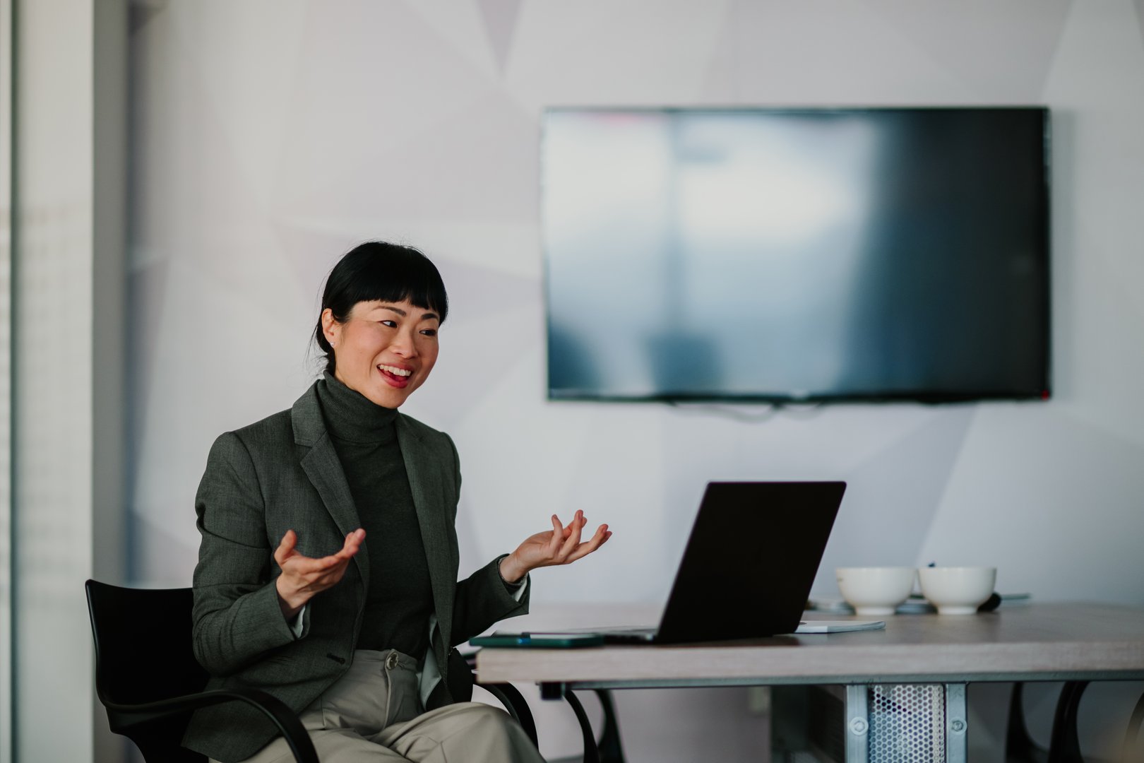 Asian businesswoman leading a video conference using laptop in modern office