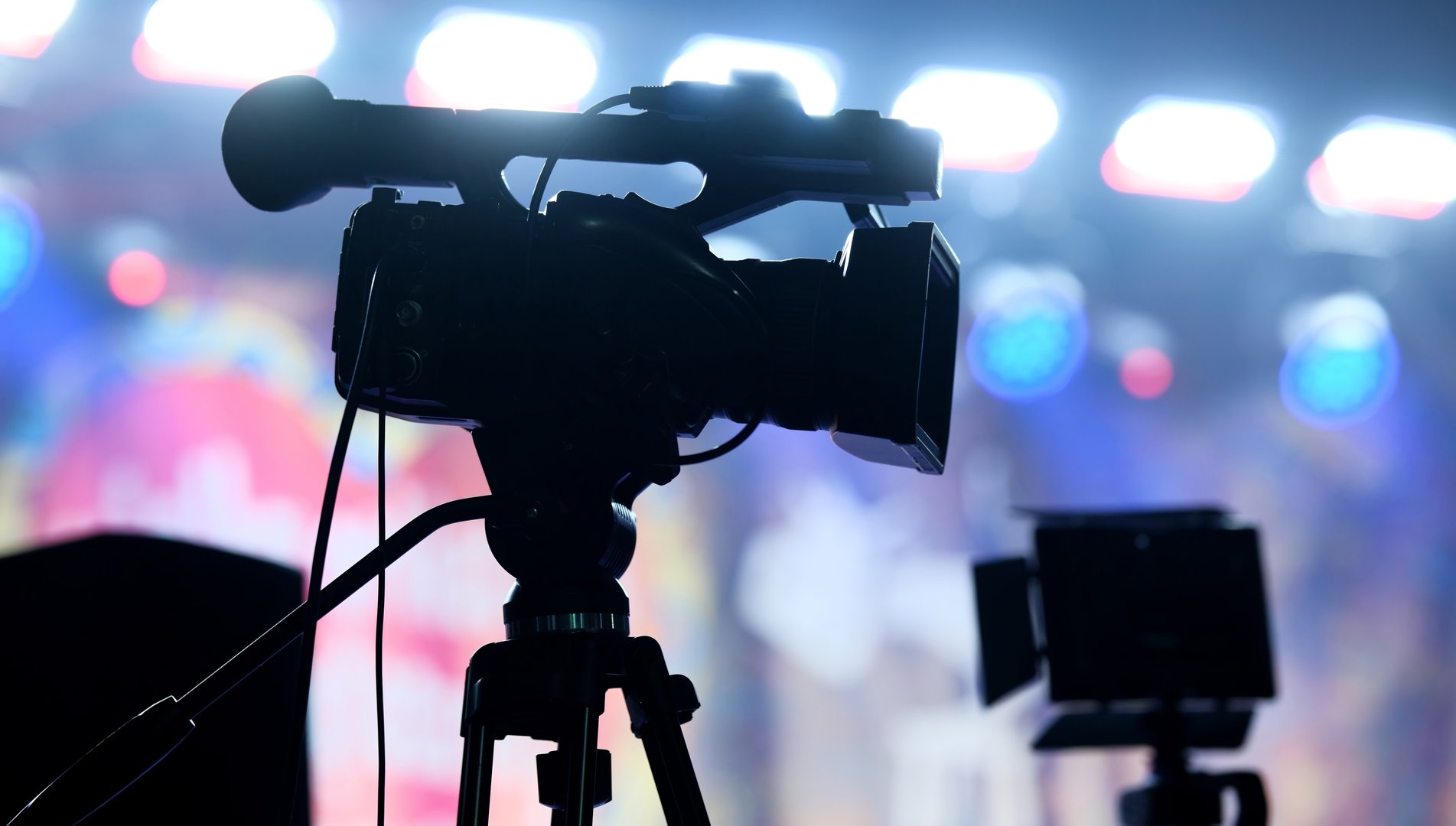 Video Camera Filming A Music Concert In Colorful Stage Lights