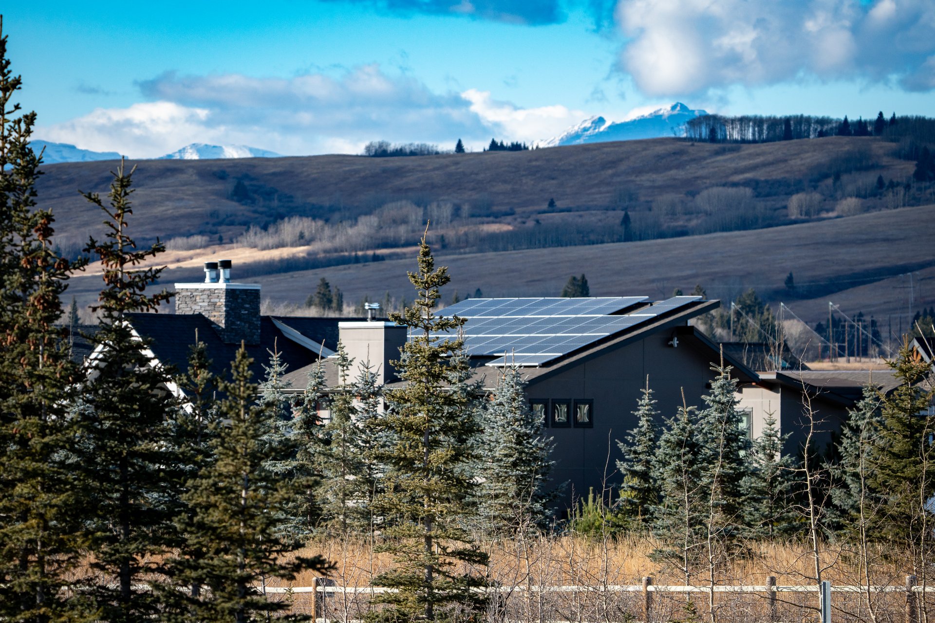 Solar panels installed on a country home roof generating electricity in a forest district.