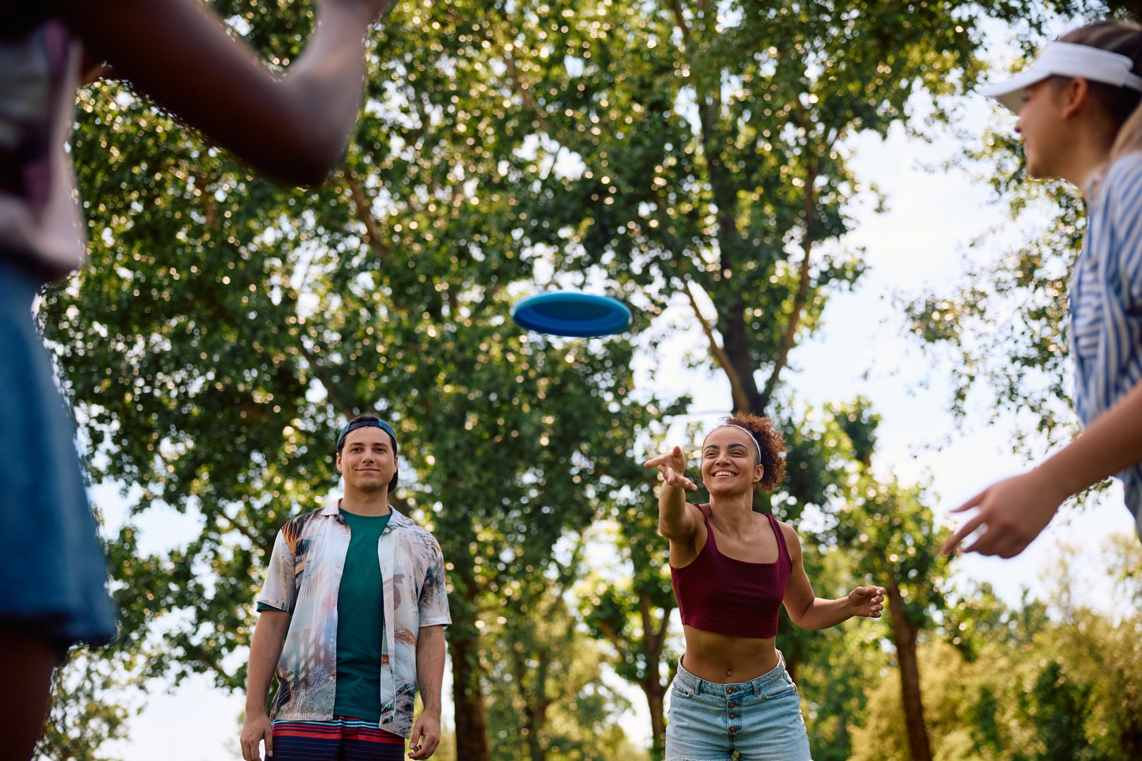 Carefree friends playing with frisbee in the park.
