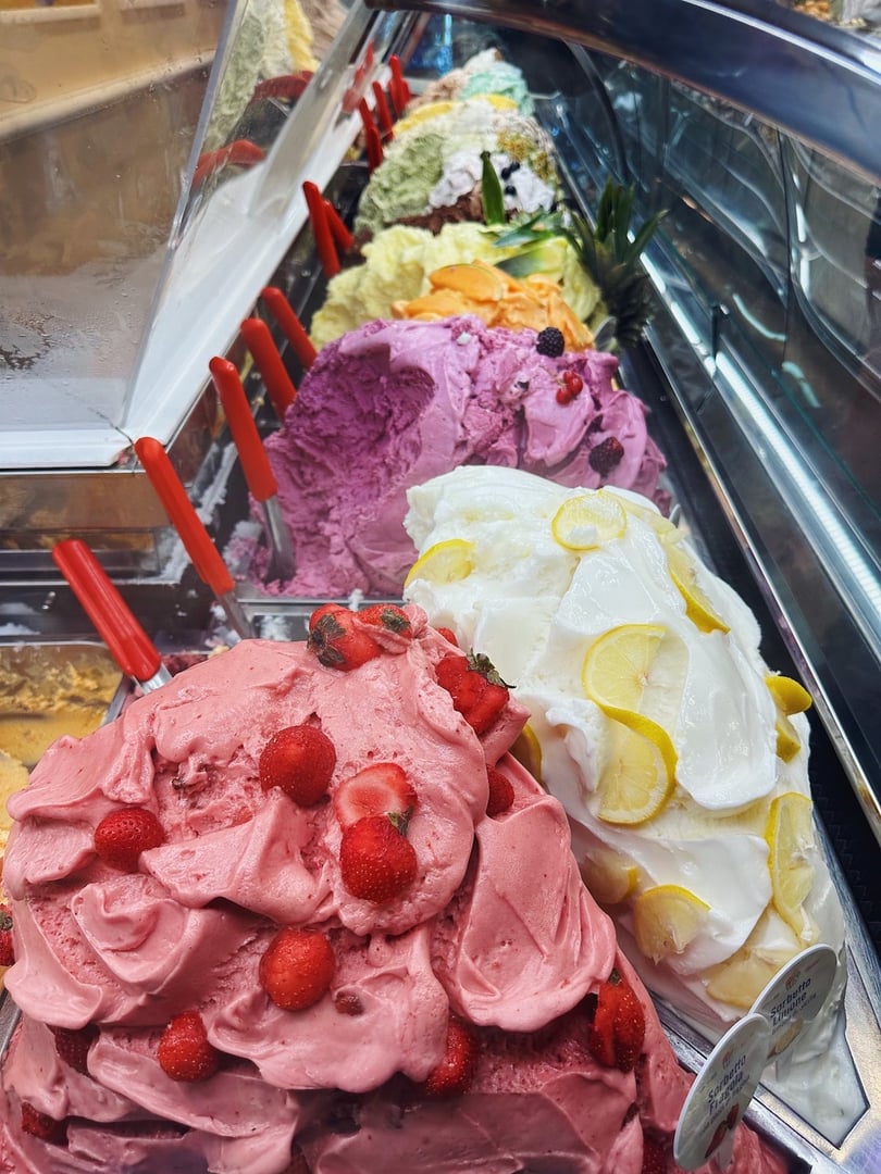 Colorful gelato with real fruit behind glass