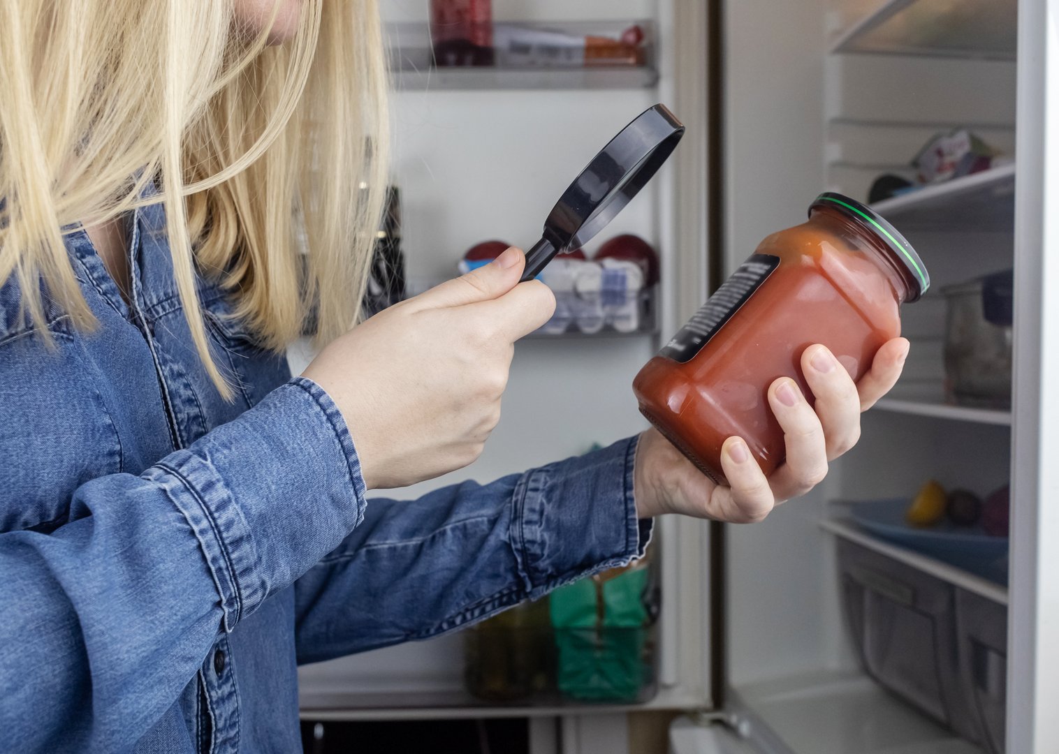 Nutritionology. Woman reads instructions for food products at home. Checking labels on goods. Study of product compositions. Search Internet for descriptions of product gradients. Useful or harmful.