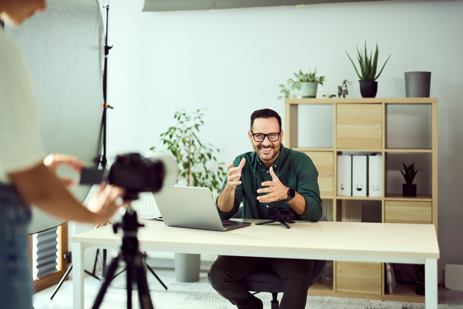 Enthusiastic content creator recording a video in a stylish well-organized office.