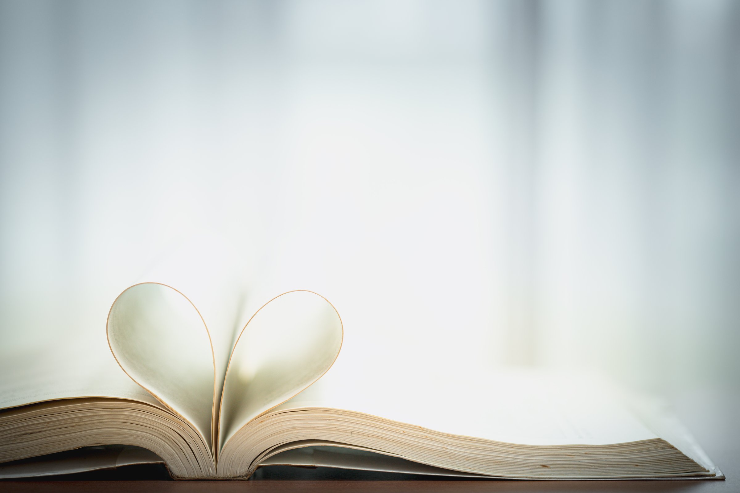 Open book with heart-shaped pages. Concept of romance, love of reading, literature passion, storytelling, and emotional connection through books.