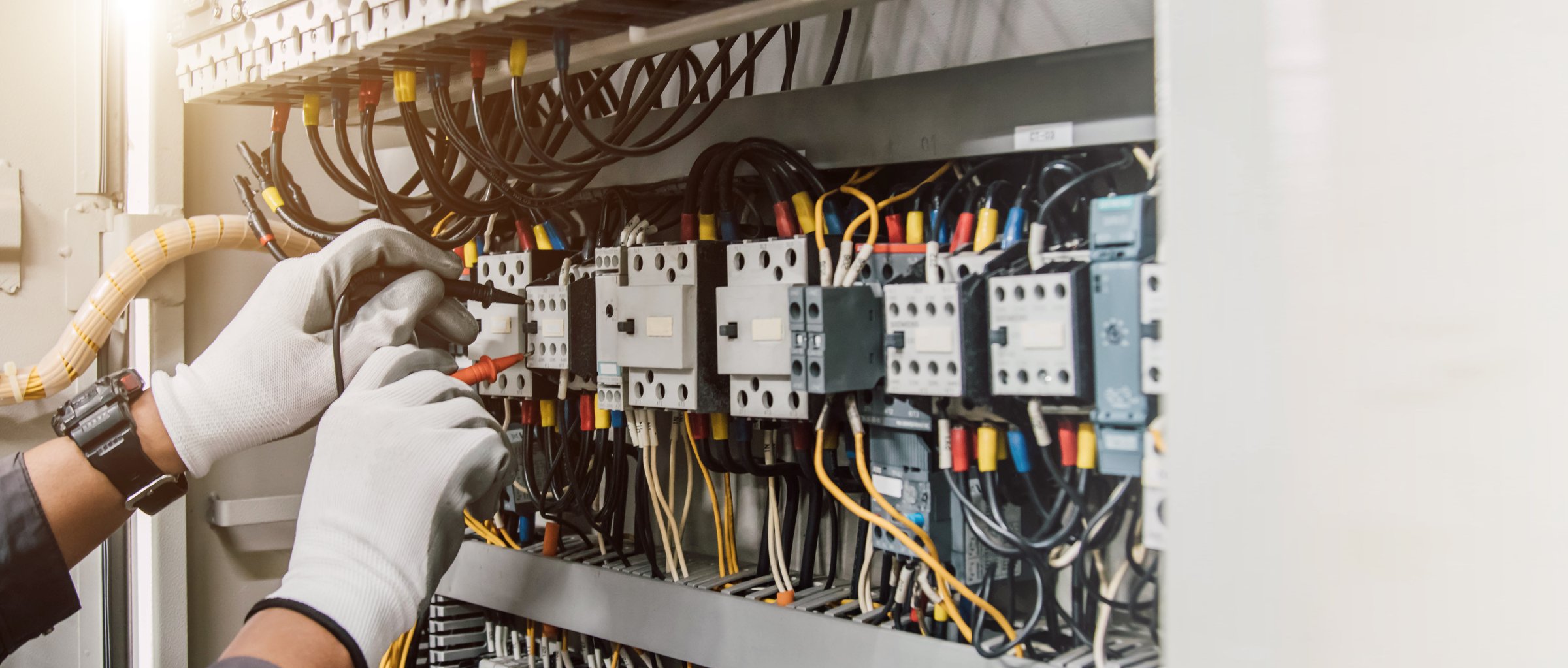 Electrician engineer tests electrical installations and wires on relay protection system.
