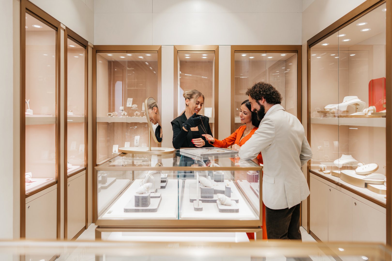 Sales assistant showing precious jewelry to a couple in a high-end luxury boutique, highlighting exceptional customer service and the experience of choosing a special gift