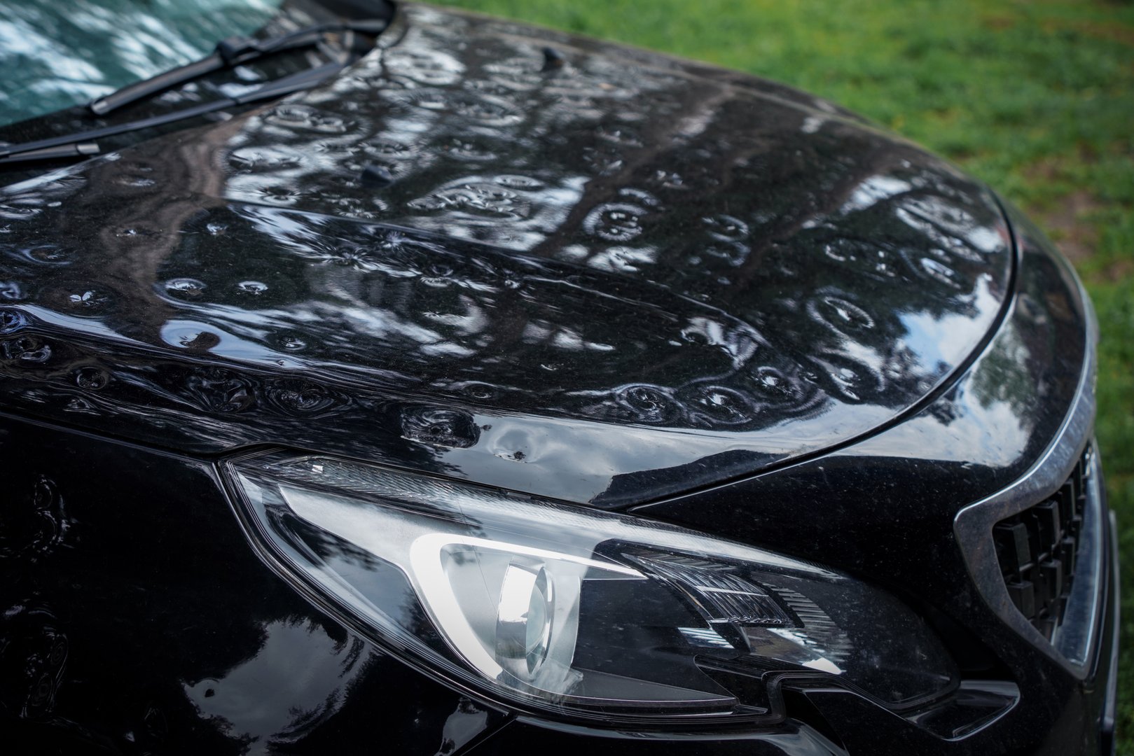 Close up of severely weather hail damaged car hood with numerous dents. The image highlights the risks of natural damage and the importance of vehicle protection and or insurance.