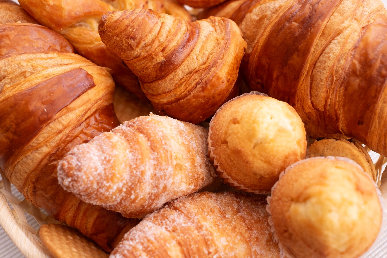 Close-up on sweet bakery products and croissant in the basket captured from above