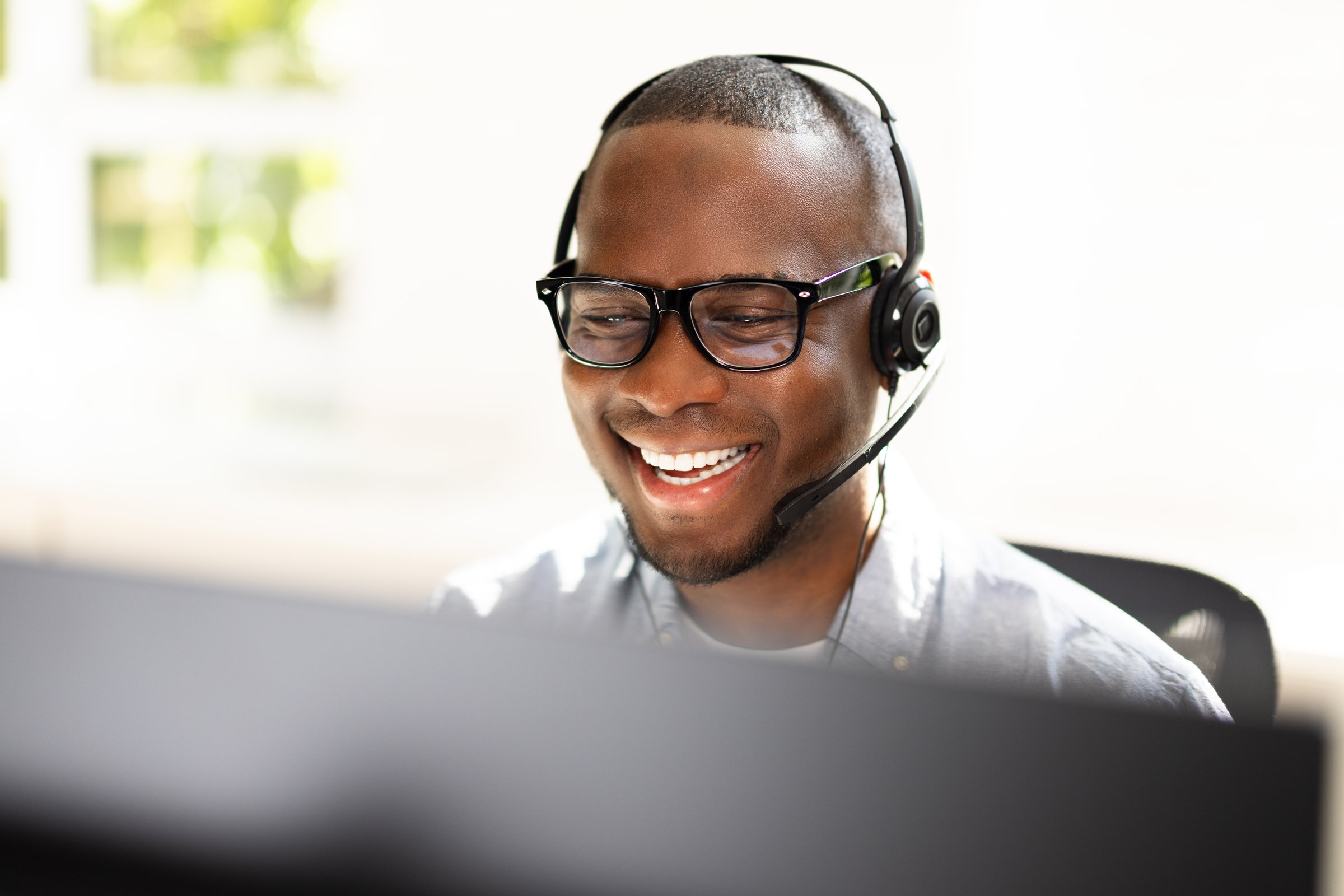 Energetic Call Center Agent Ensuring Customer Satisfaction Over the Phone in a Lively Office Setting for Tech Support Team.