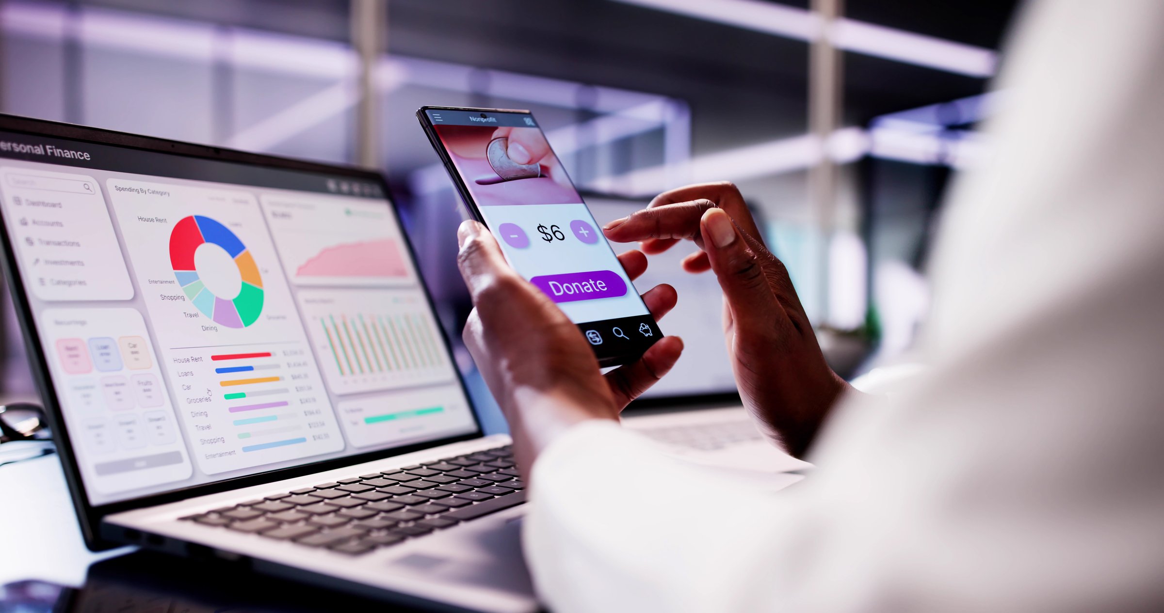 African American woman using smartphone app to donate money online, supporting charities and investing in financial funds.