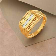 Gold ring with an intricate rectangular design and light blue enamel inlay, placed on a textured beige surface.