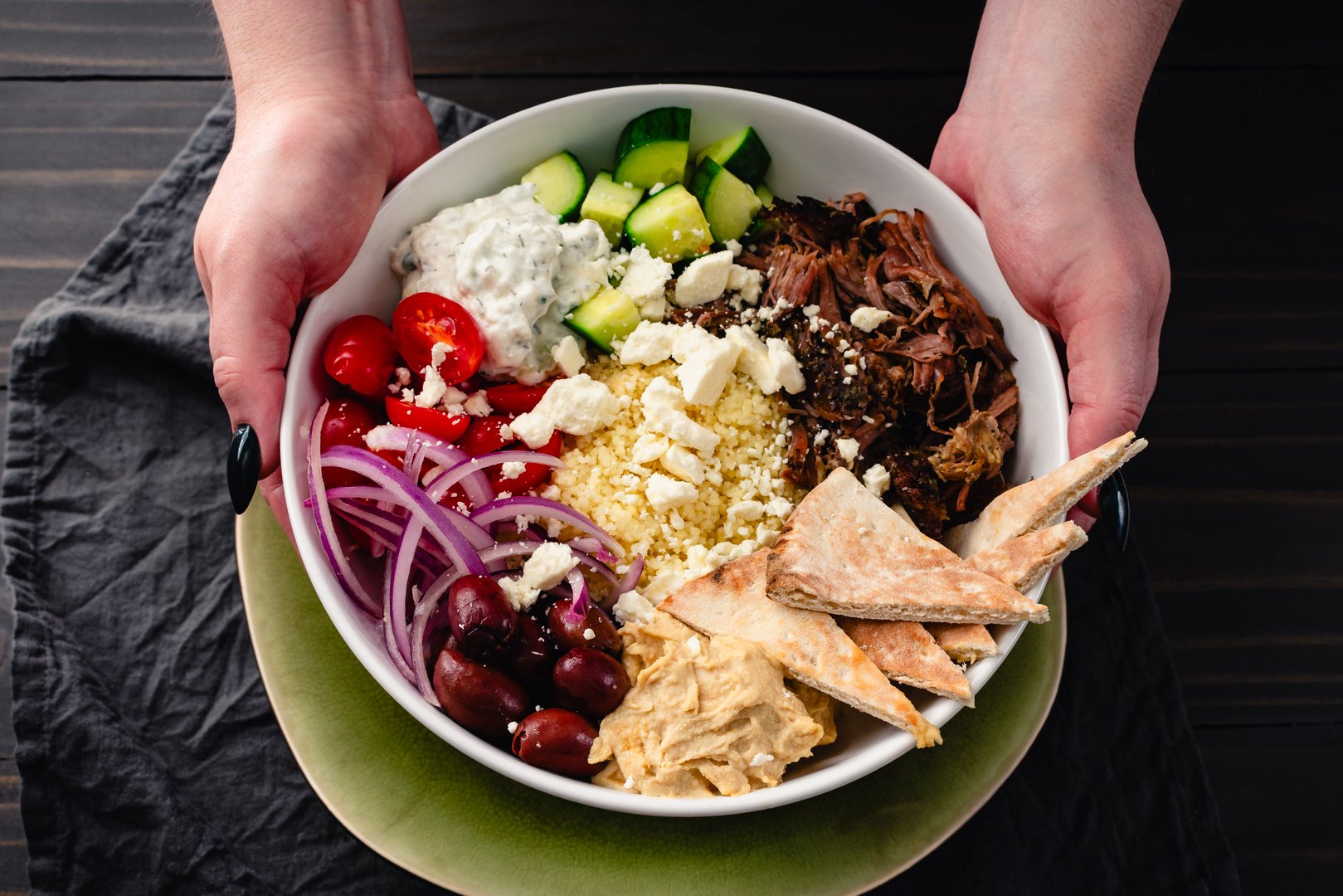 Couscous with tzatziki, feta, black olives, cucumber, tomatoes, hummus & pita