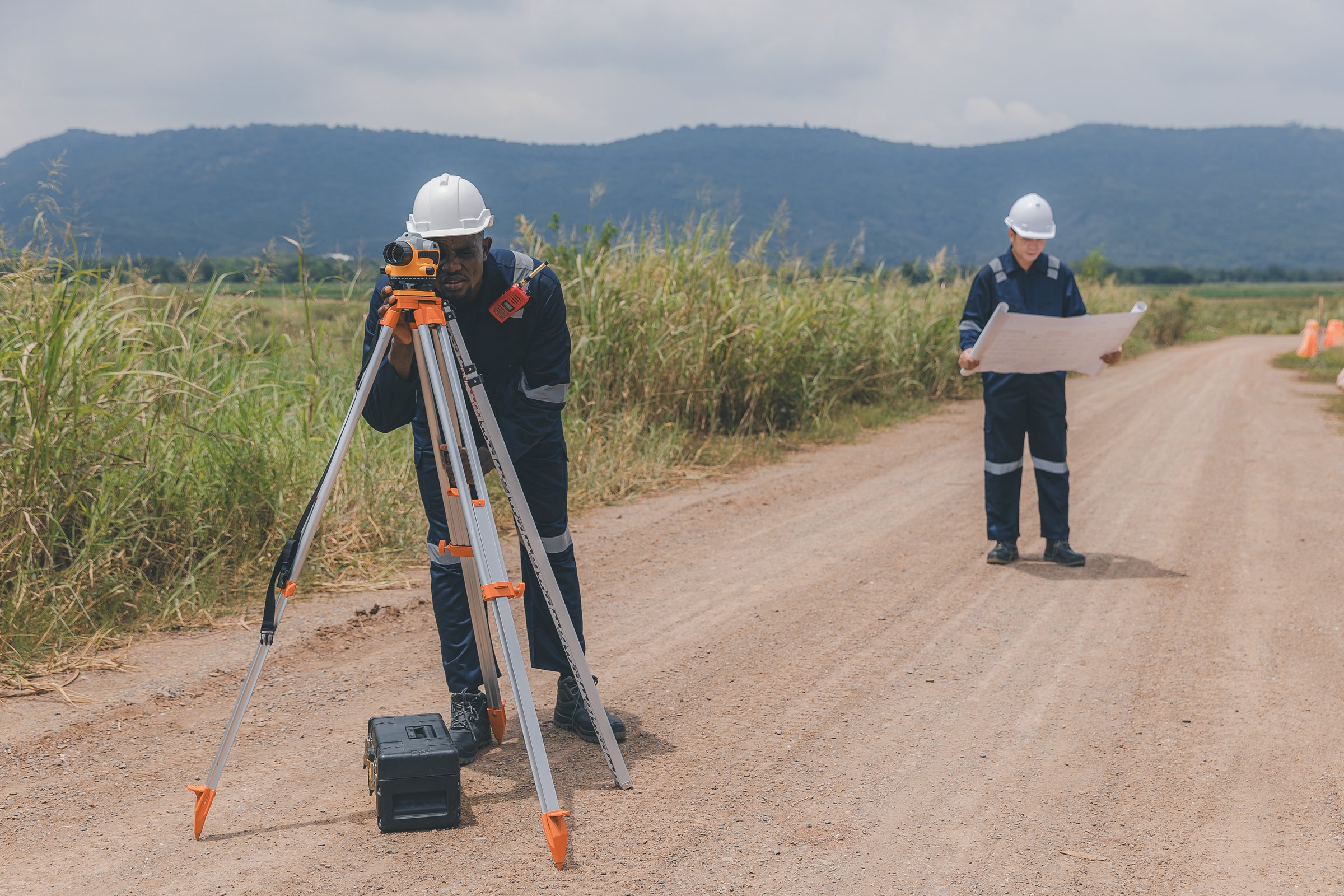 Surveyor engineer worker making measuring with theodolite tool equipment at construction site. Surveyors or explorer view construction sites or check security