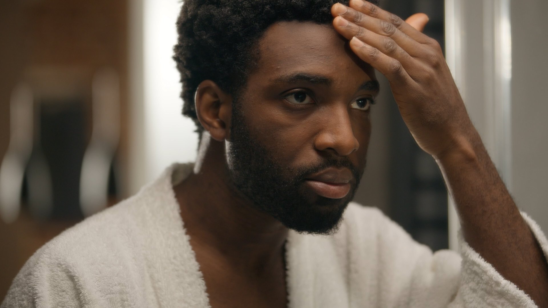 African American man looking at mirror reflection hotel bathroom smiling bearded guy shaving beard lotion gel cream soft skin shave face grooming morning hygiene male cosmetics facial care moisturize. High quality 4k footage