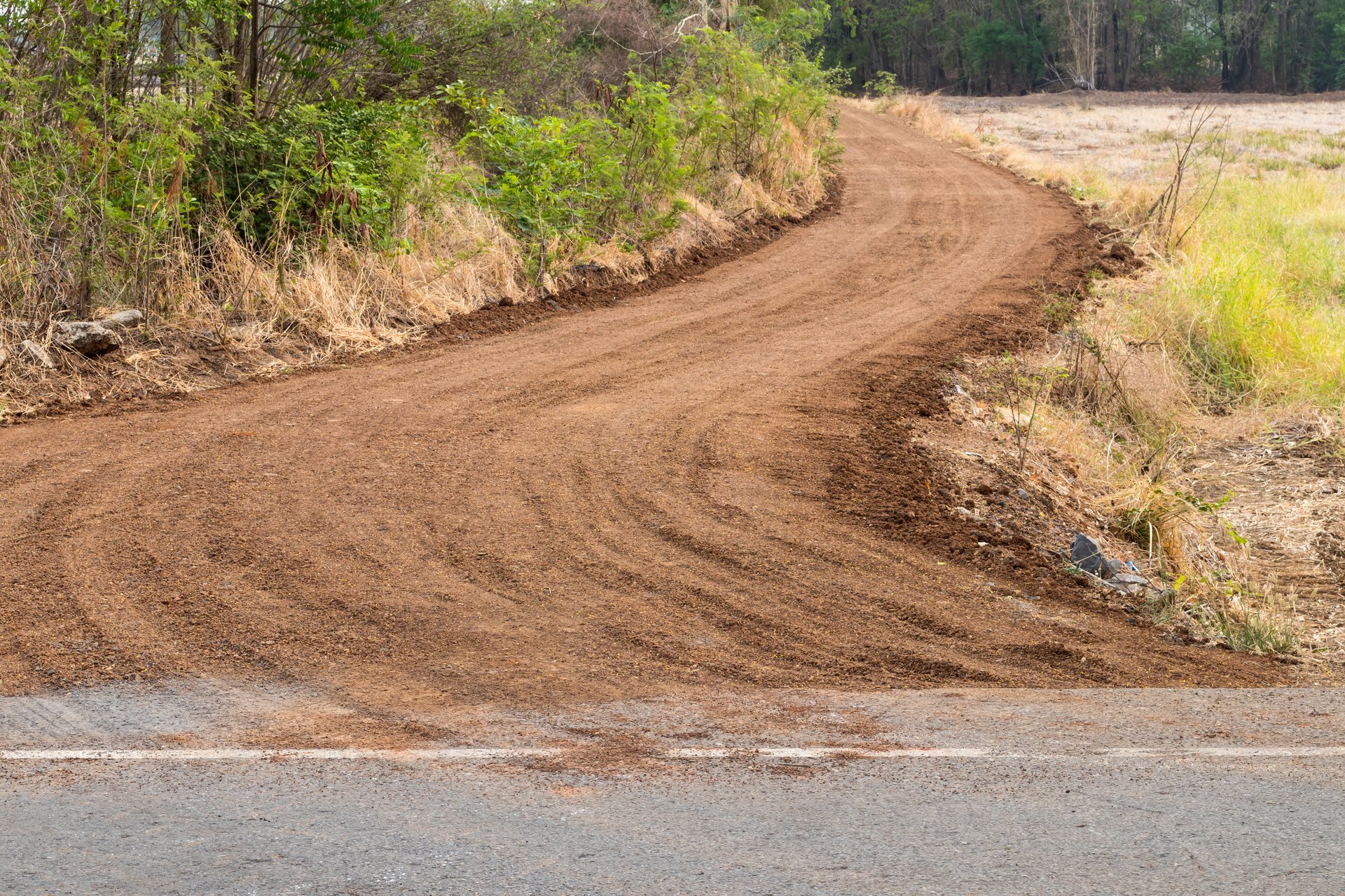 View of the dirt road, the curve connecting the paved road through the rice paddy area.