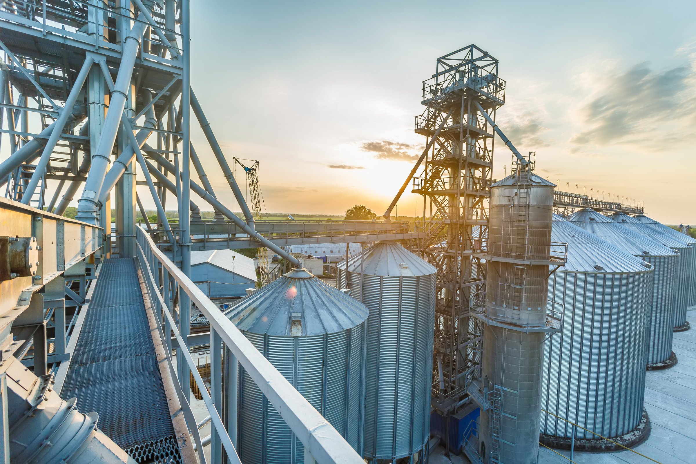 Panoramic view of industrial silos and grain storage facilities at sunset. elevator view from above, grain storage facility