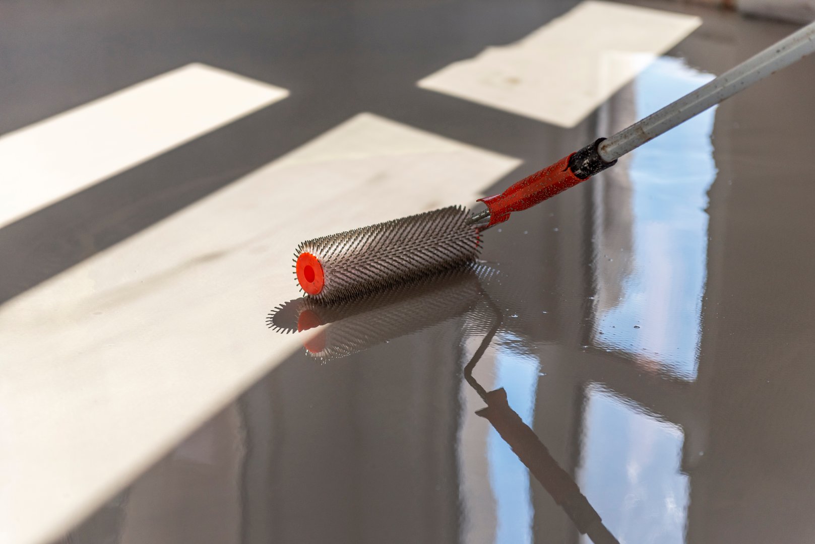 Needle roller for self-leveling floors. Leveling the floors with a cement mixture.