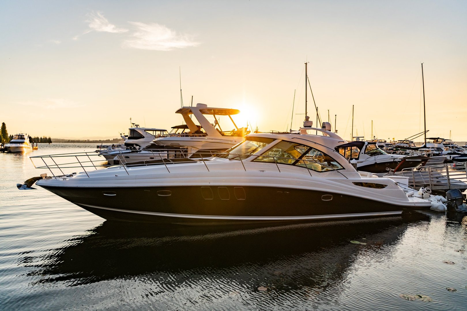 Luxury yacht in the evening sunset. Yacht club marina. Summer vacation. Downtown city marina with luxury yacht. Docked vessels. Luxury yacht in sunset marina.