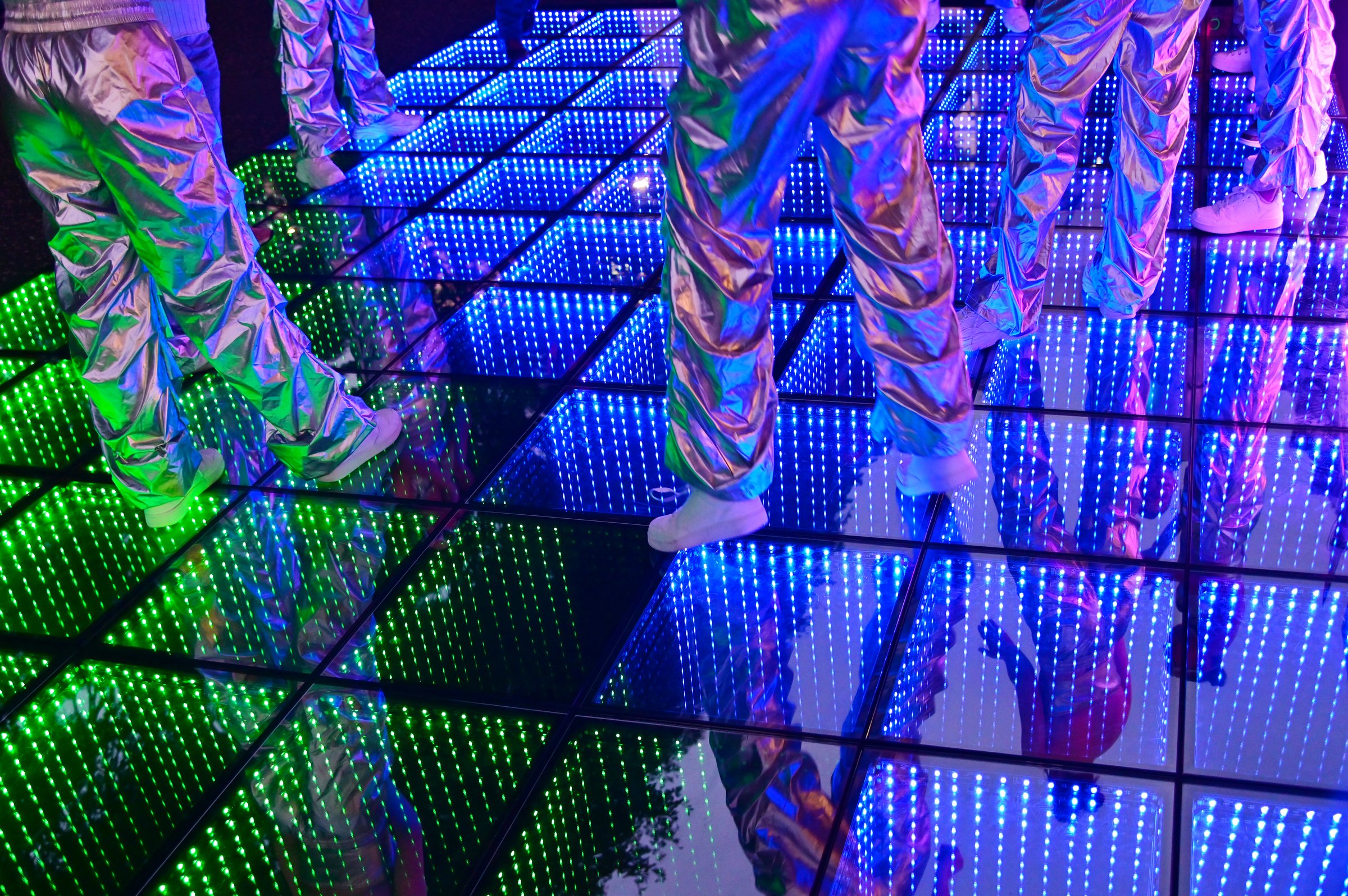 Unrecognizable group of people dancing on LED dance floor