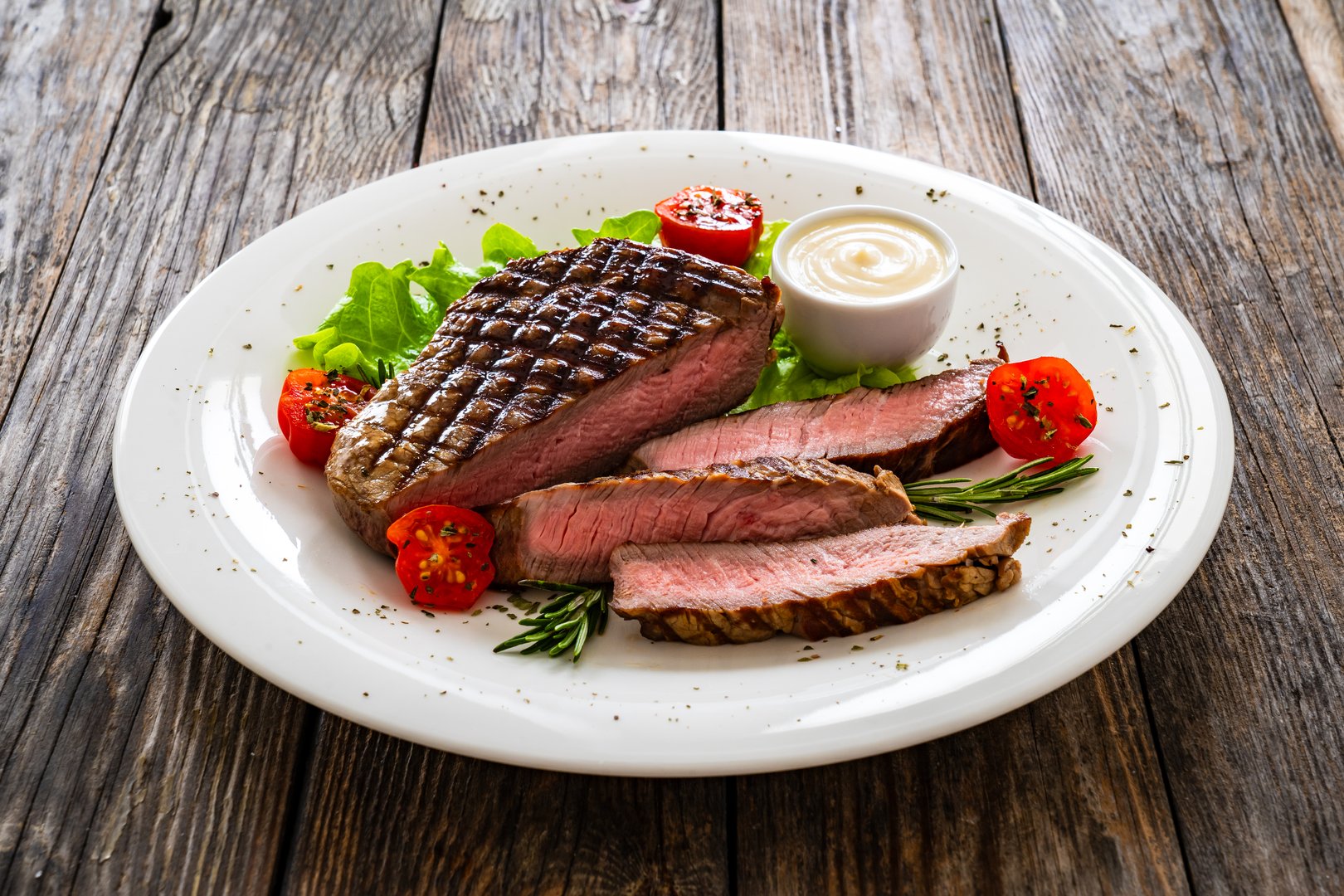 Grilled beef sirloin steak with fresh vegetables on wooden background