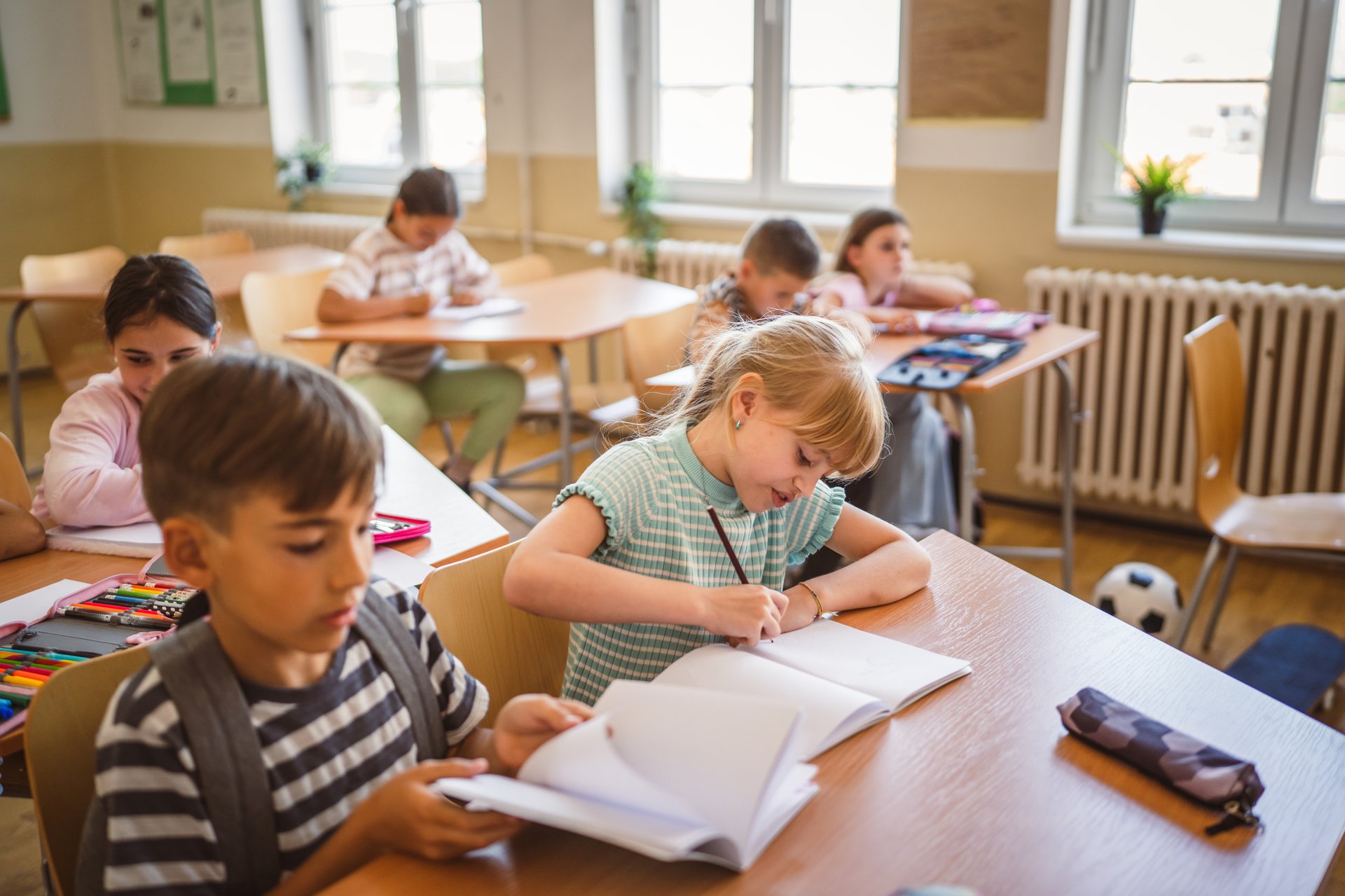 school girl and boy pupil write notes and attend class in the classroom