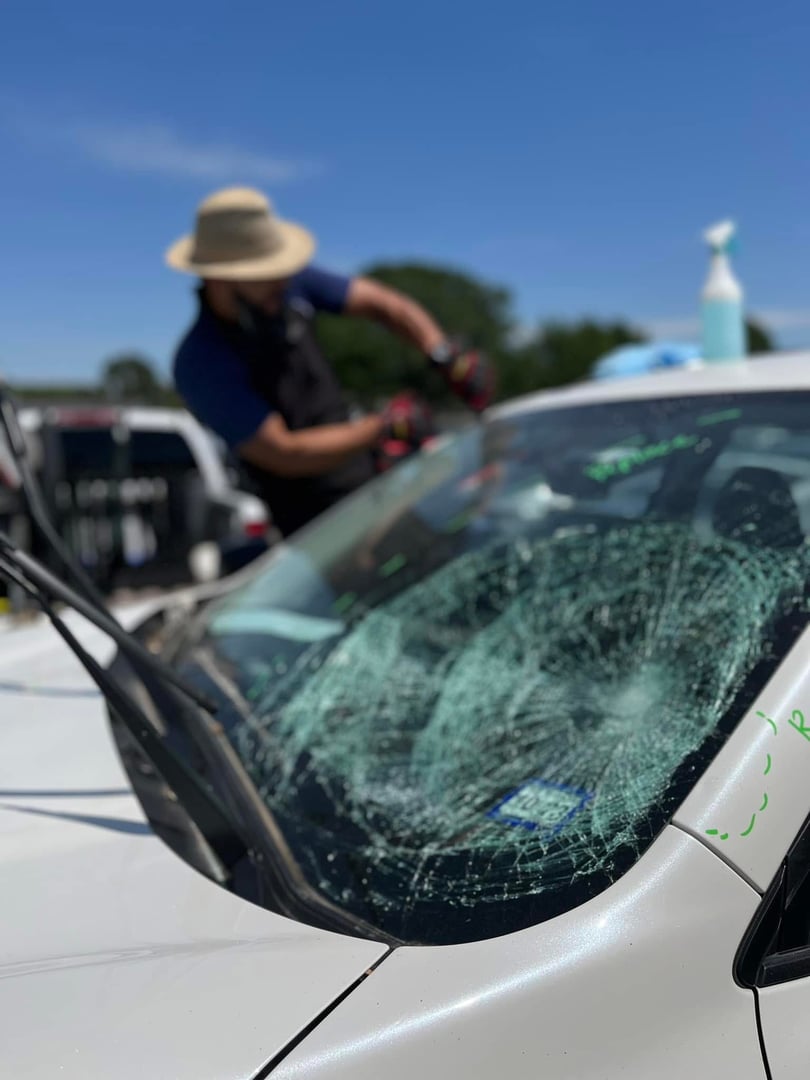 Auto glass service technician working on vehicle