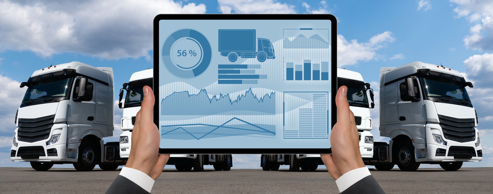 Manager with a digital tablet on the background of trucks. Fleet management.