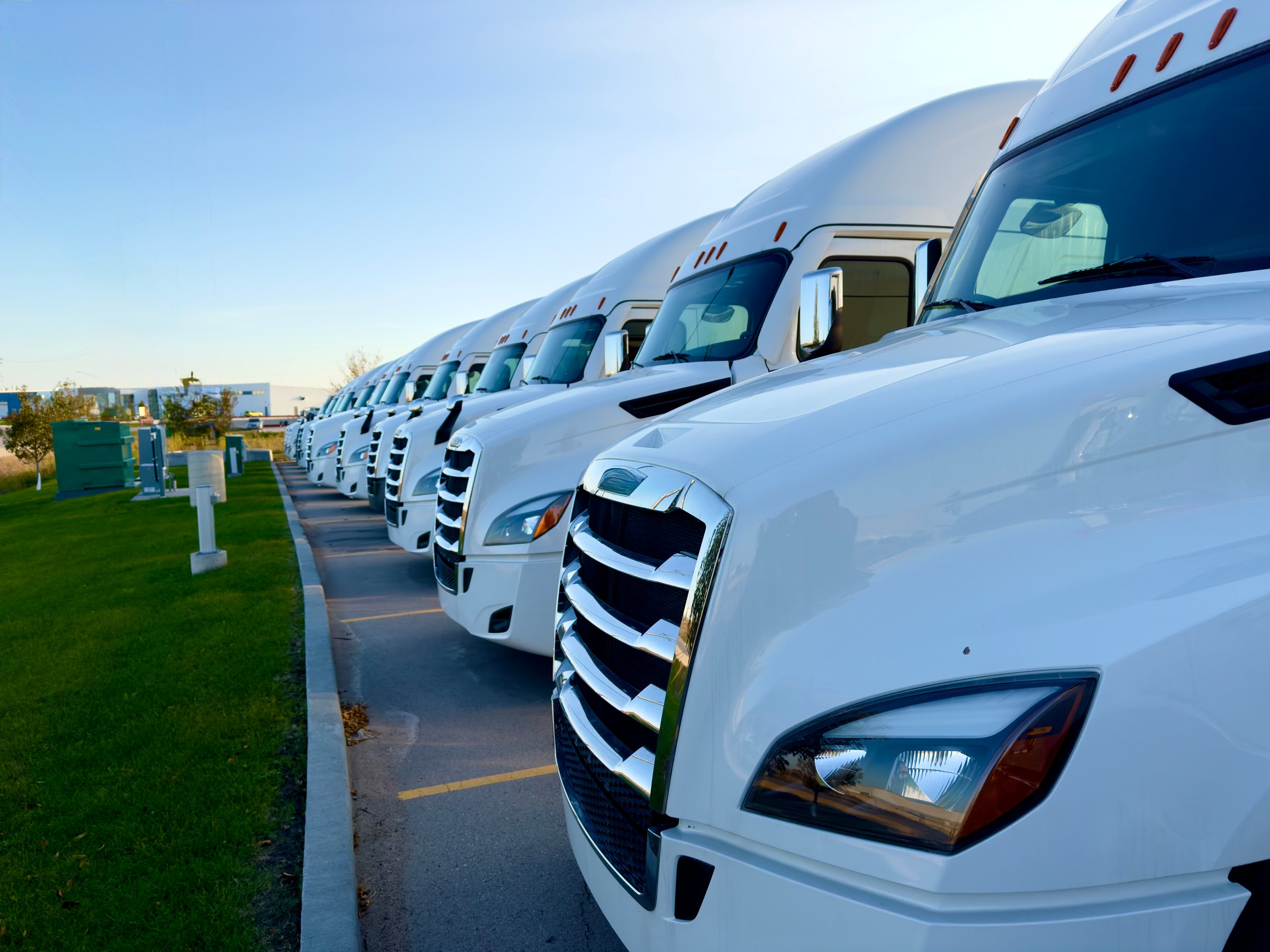 parking of several white trucks in a parking lot