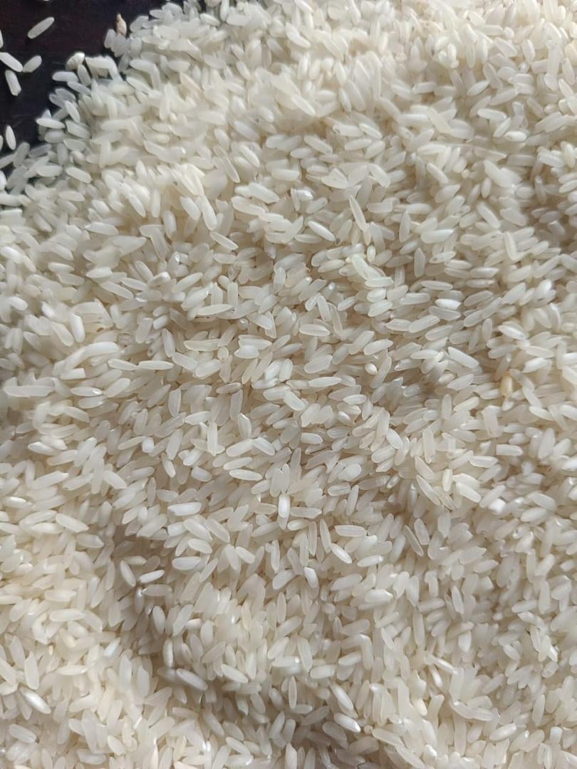 A close-up view of a pile of uncooked white rice grains filling the frame.