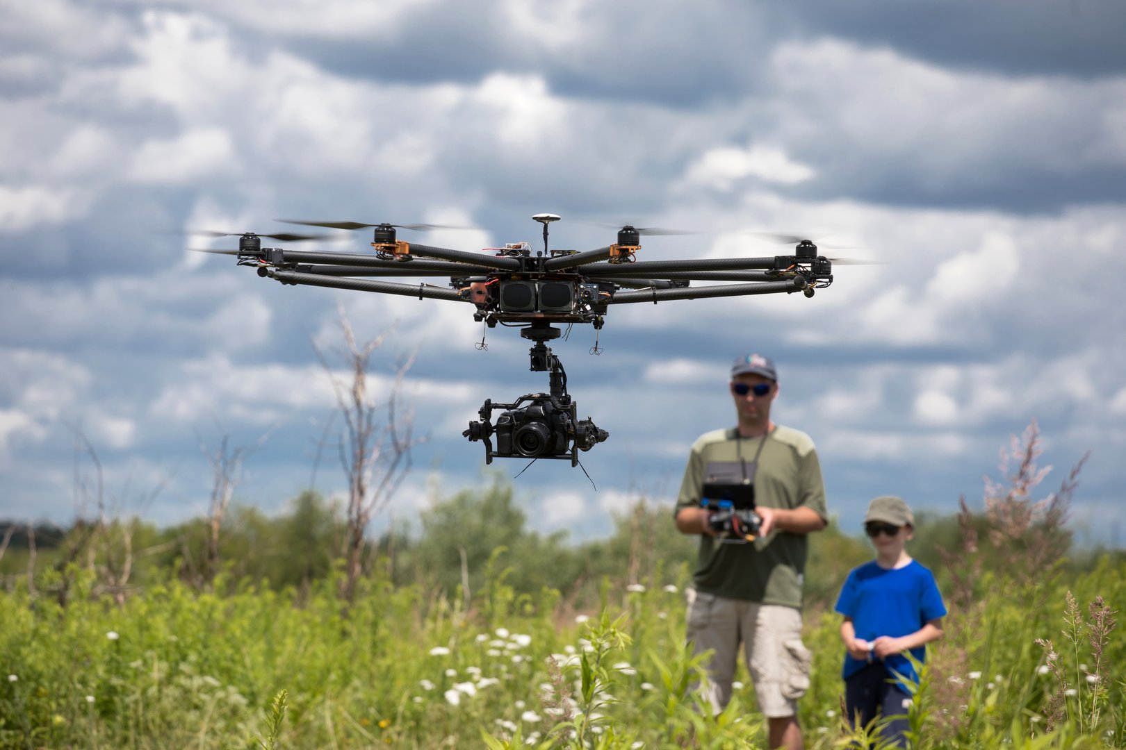 father trains son piloting drone