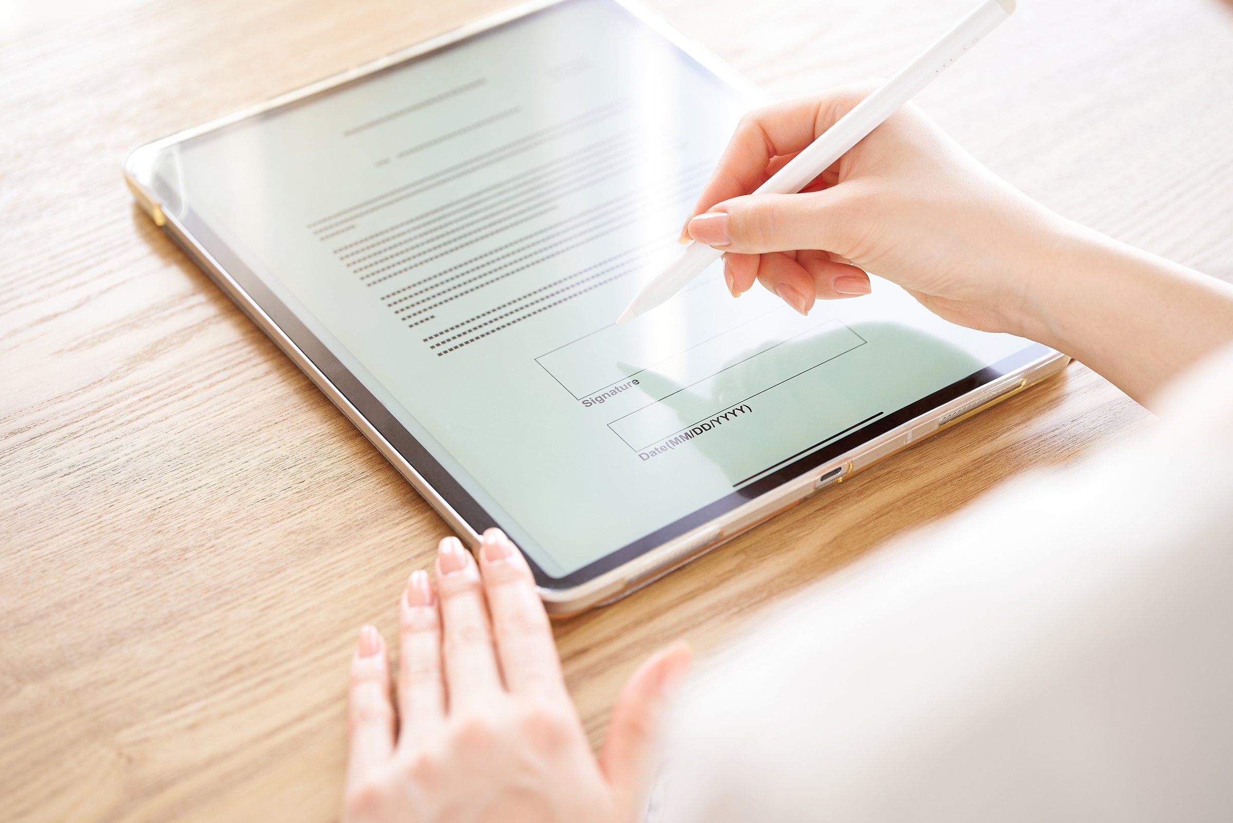 Hand of a woman who makes an electronic signature with a stylus pen