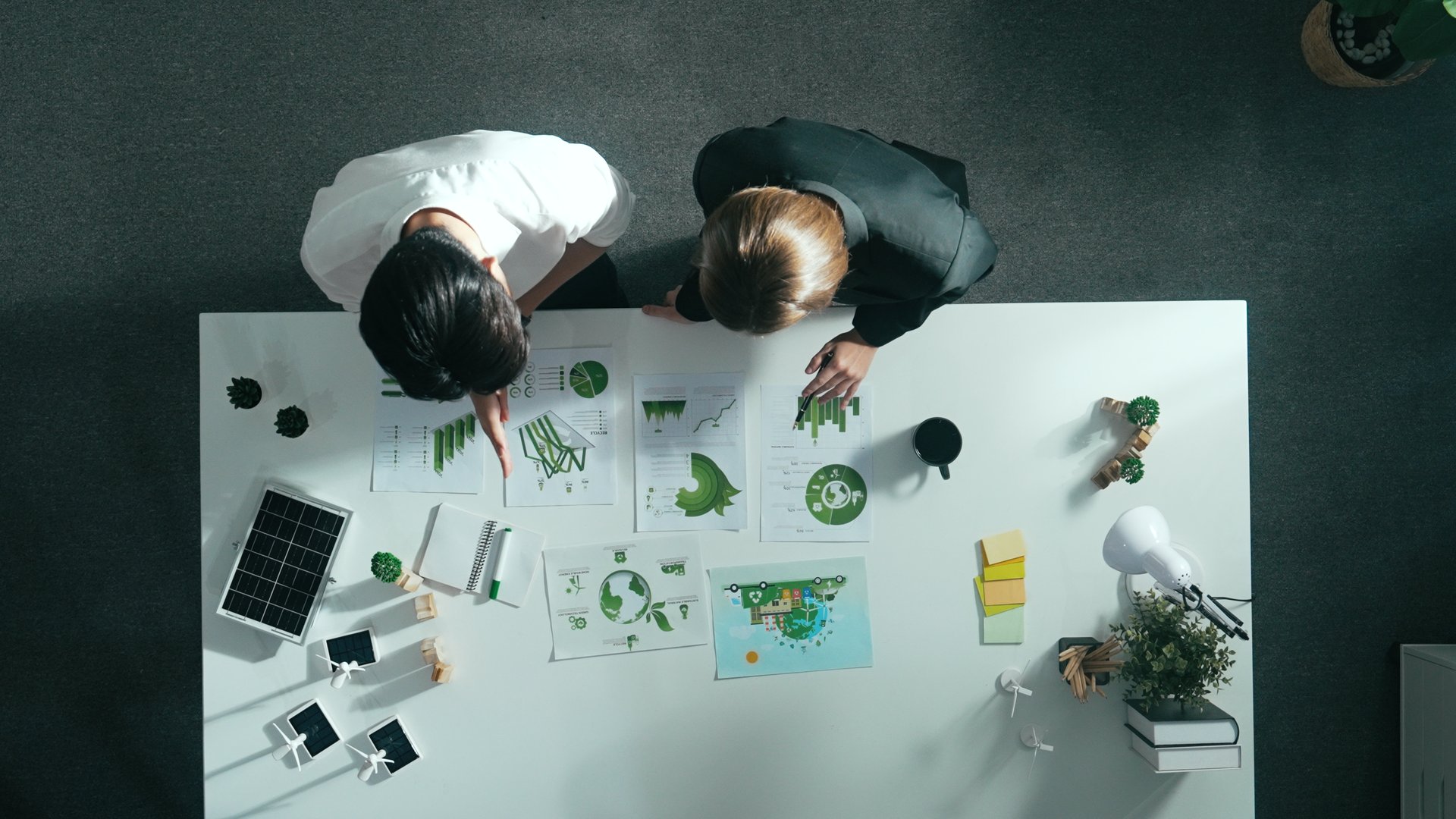 Top aerial view of businessman and manager talking about clean energy investment. Aerial view of business team working together planning to use renewable energy. ESG modern development. Alimentation.