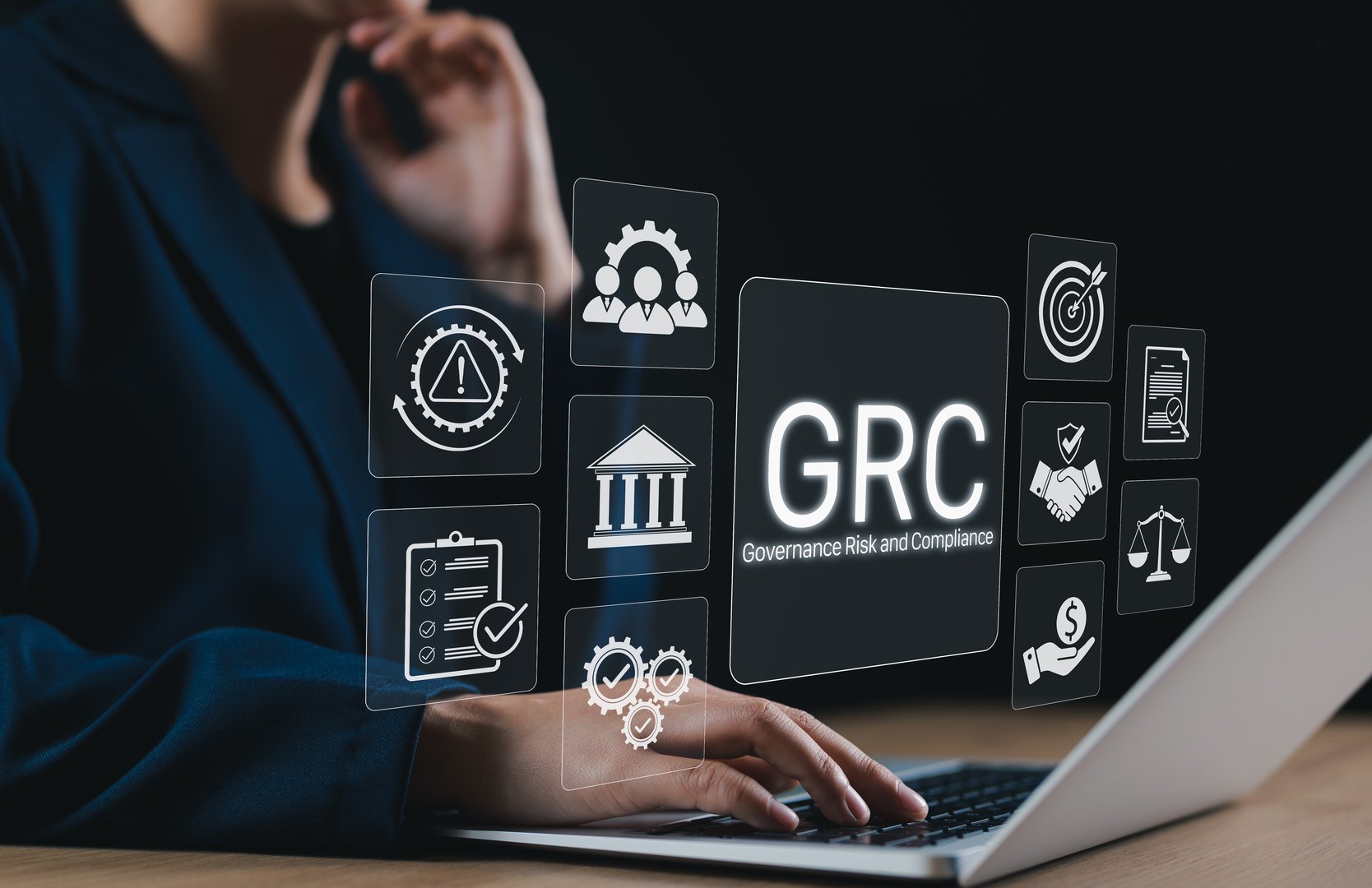 Business Concept of Governance Risk and Compliance (GRC). Businesswoman using laptop with GRC icons representing governance, risk management, ethics, compliance, corporate control, and responsibility.