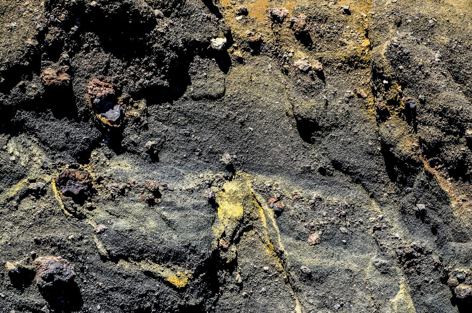 A rocky surface with a yellowish tint. The rocks are scattered all over the surface. The image has a somewhat somber and desolate mood