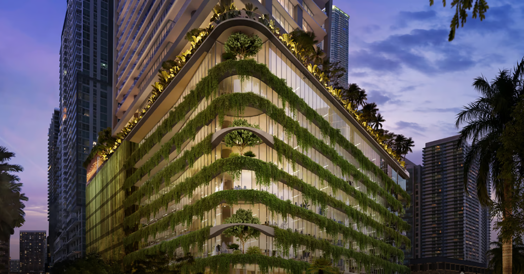 Modern building with green vertical gardens and large windows, set against a cityscape at dusk.
