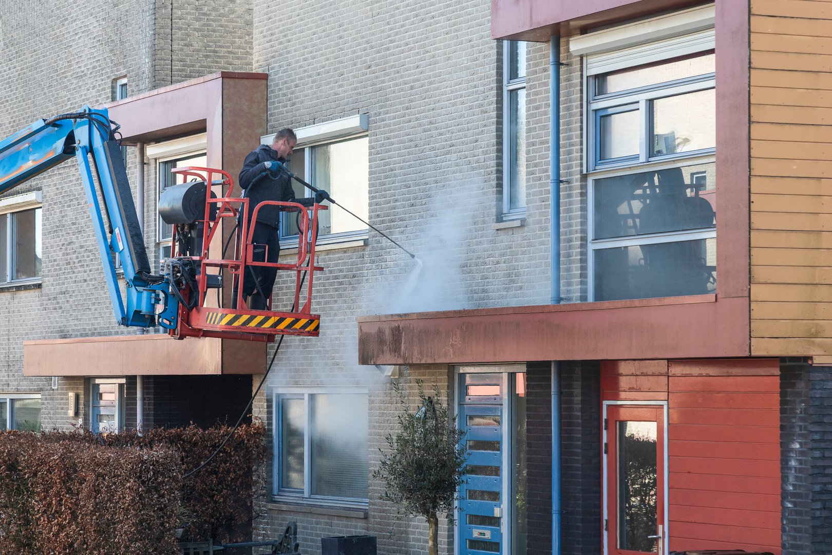 Soest, Netherlands, April 7, 2025; Employee cleans the front facade of a house with a high-pressure cleaner.