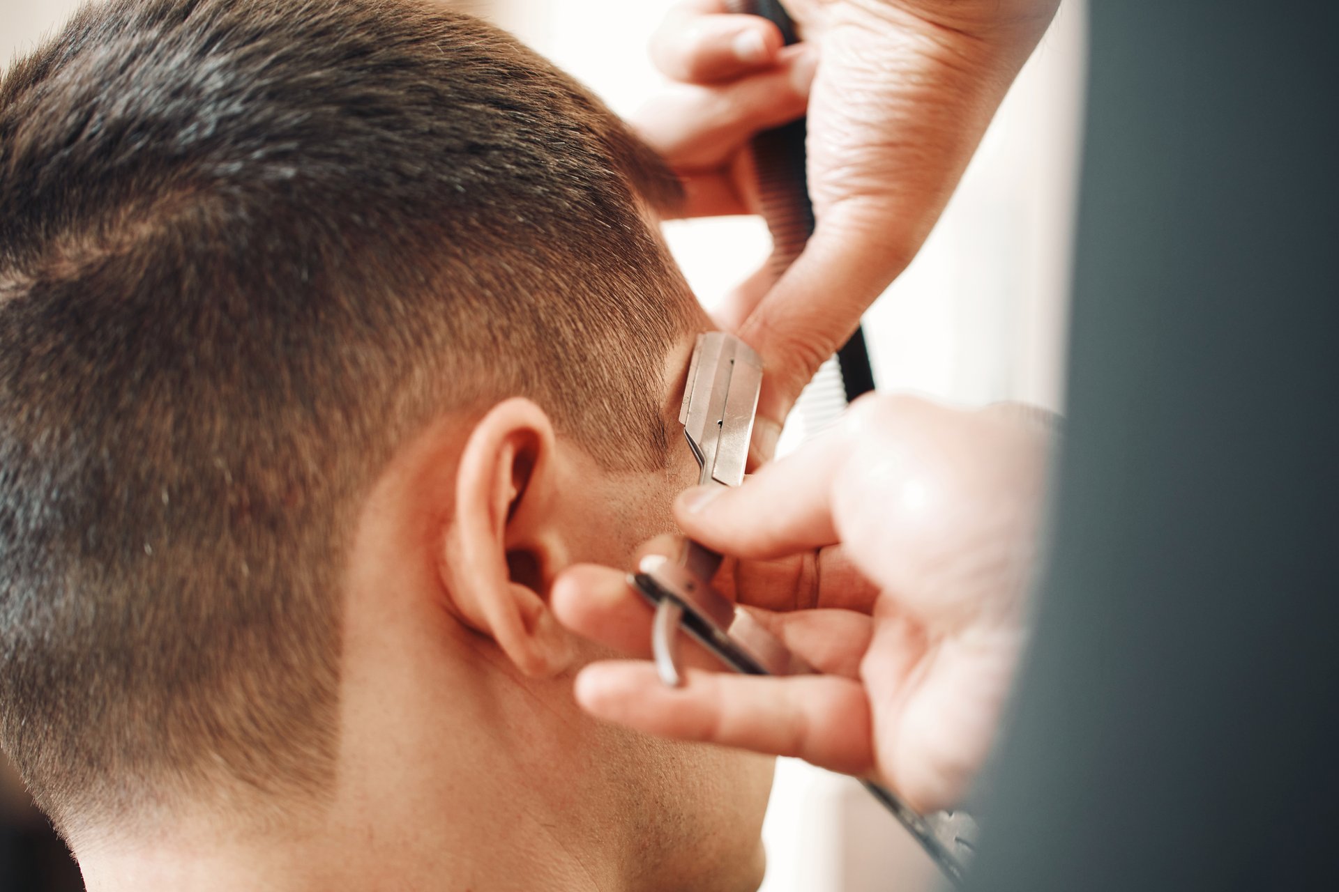 Barber shaving bearded man with retro knife in barber shop. close-up
