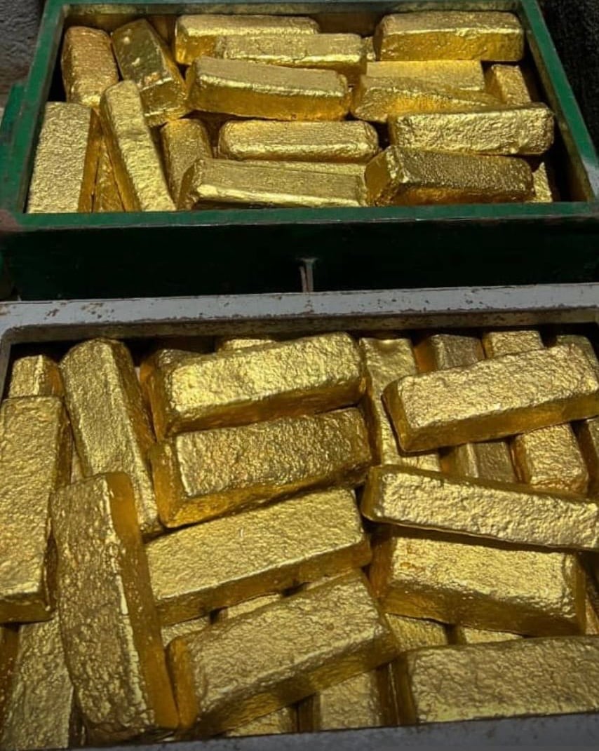 Two boxes filled with numerous gold bars stacked closely together.