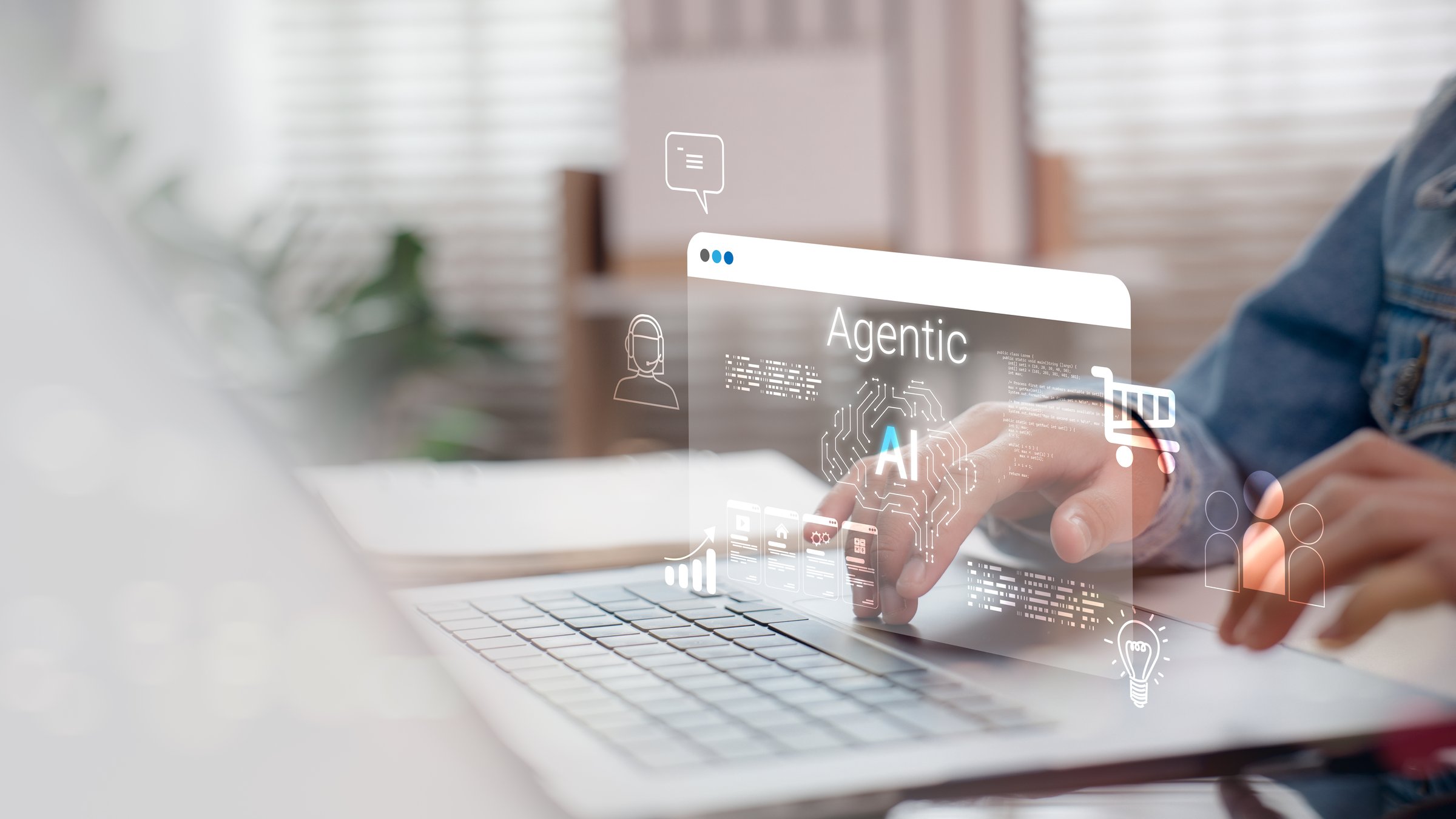 Person interacting with Agentic AI interface on laptop, featuring chatbot, analytics, shopping cart, and user icons, representing artificial intelligence in modern digital business platforms.