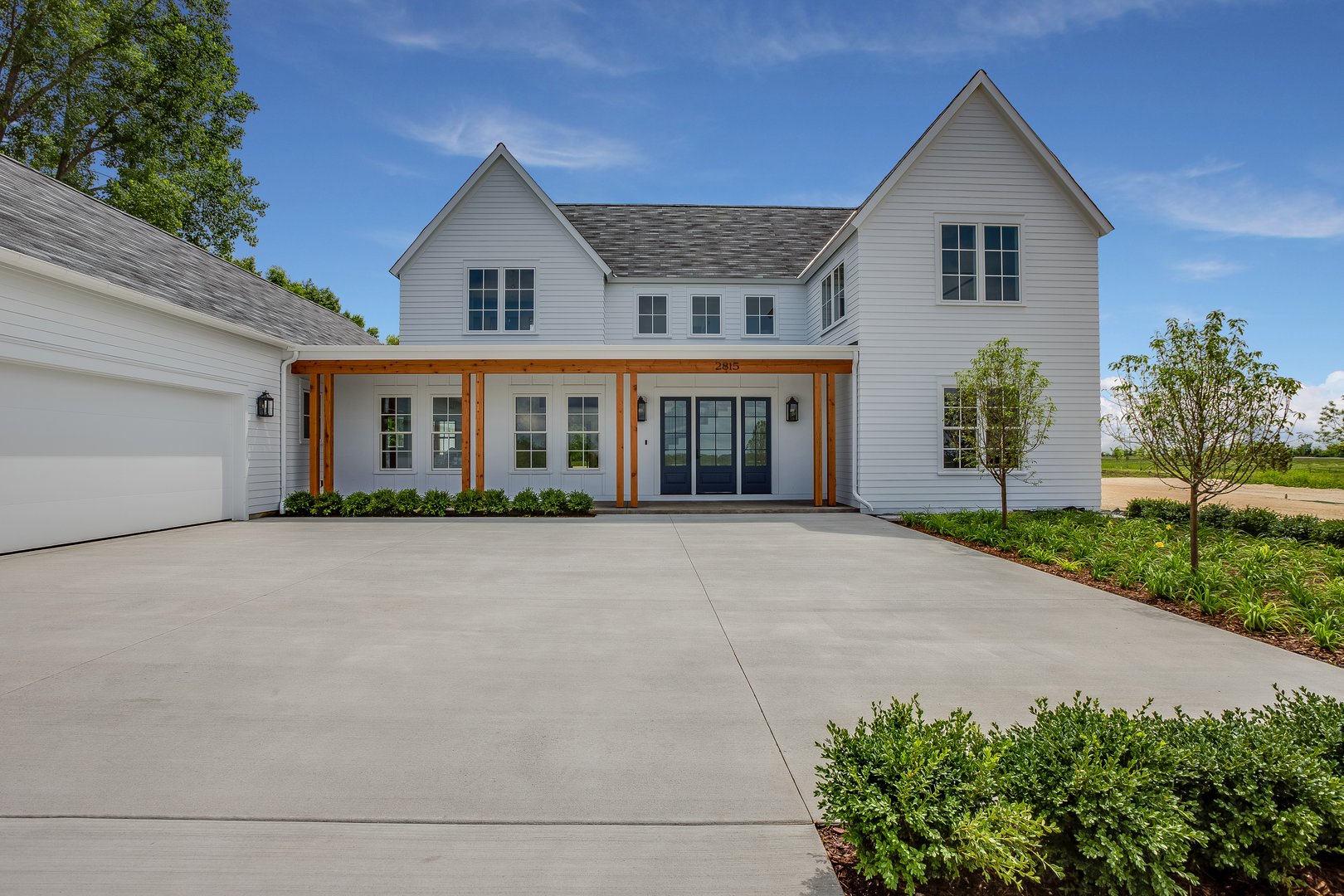 Natural wood beams and white hardie board on new home